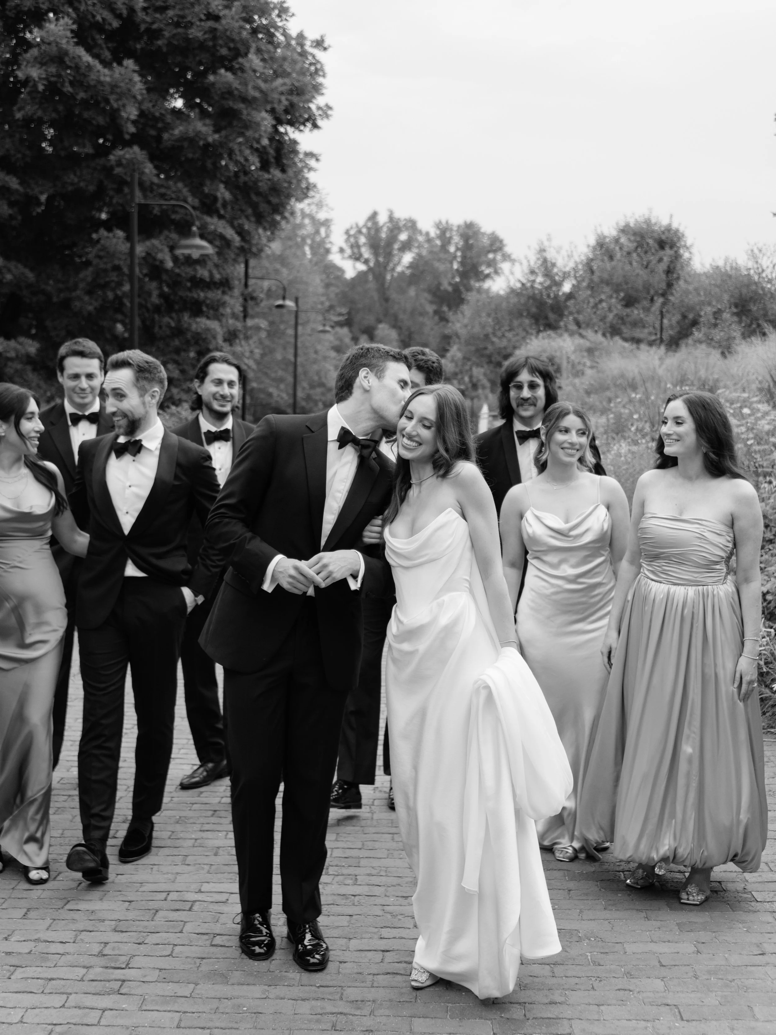 Jennie and Will walk with their wedding party through the gardens during portraits at Blue Hill at Stone Barns.