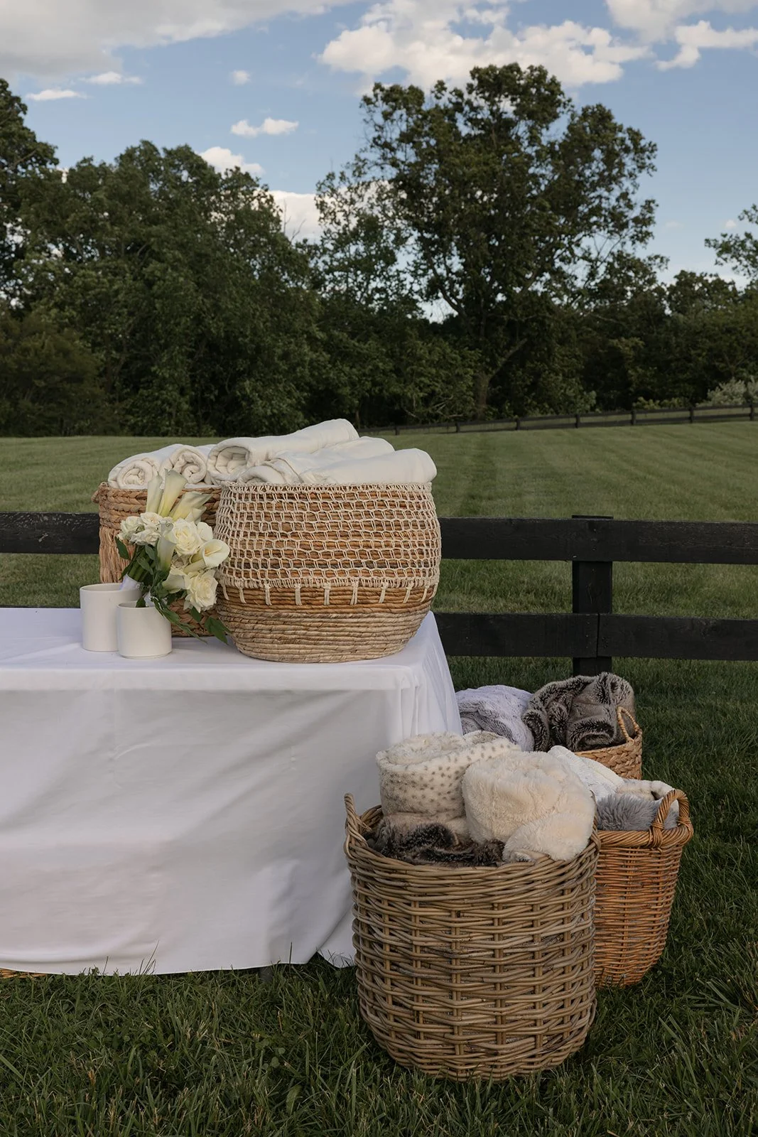 Woven baskets and white linen blankets arranged on a display table in the Hayfield at Goodstone Inn.
