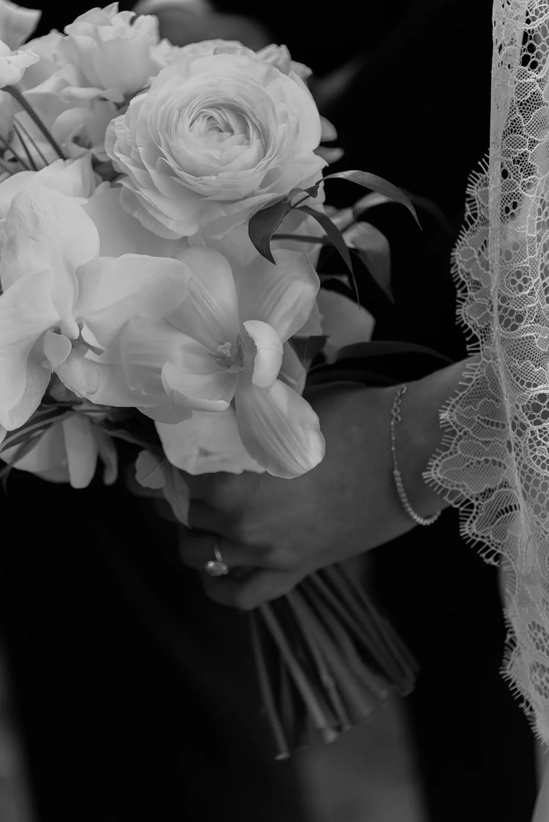 Black-and-white close-up of the bride’s white bouquet during the ceremony at Goodstone Inn.