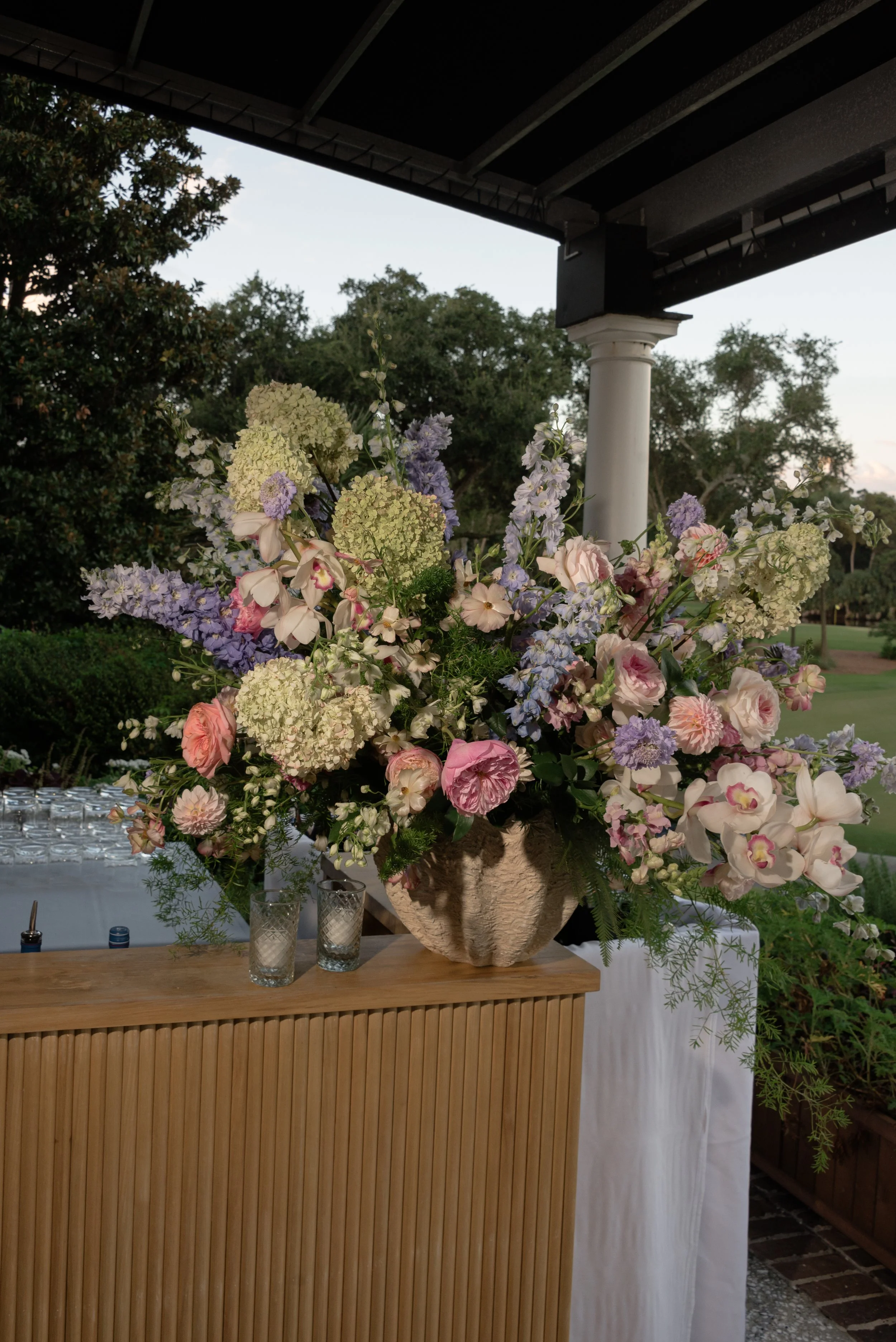 Pastel floral arrangement by Festoon displayed on the terrace at Turtle Point Clubhouse during Katie and Trevor’s Kiawah Island welcome party.