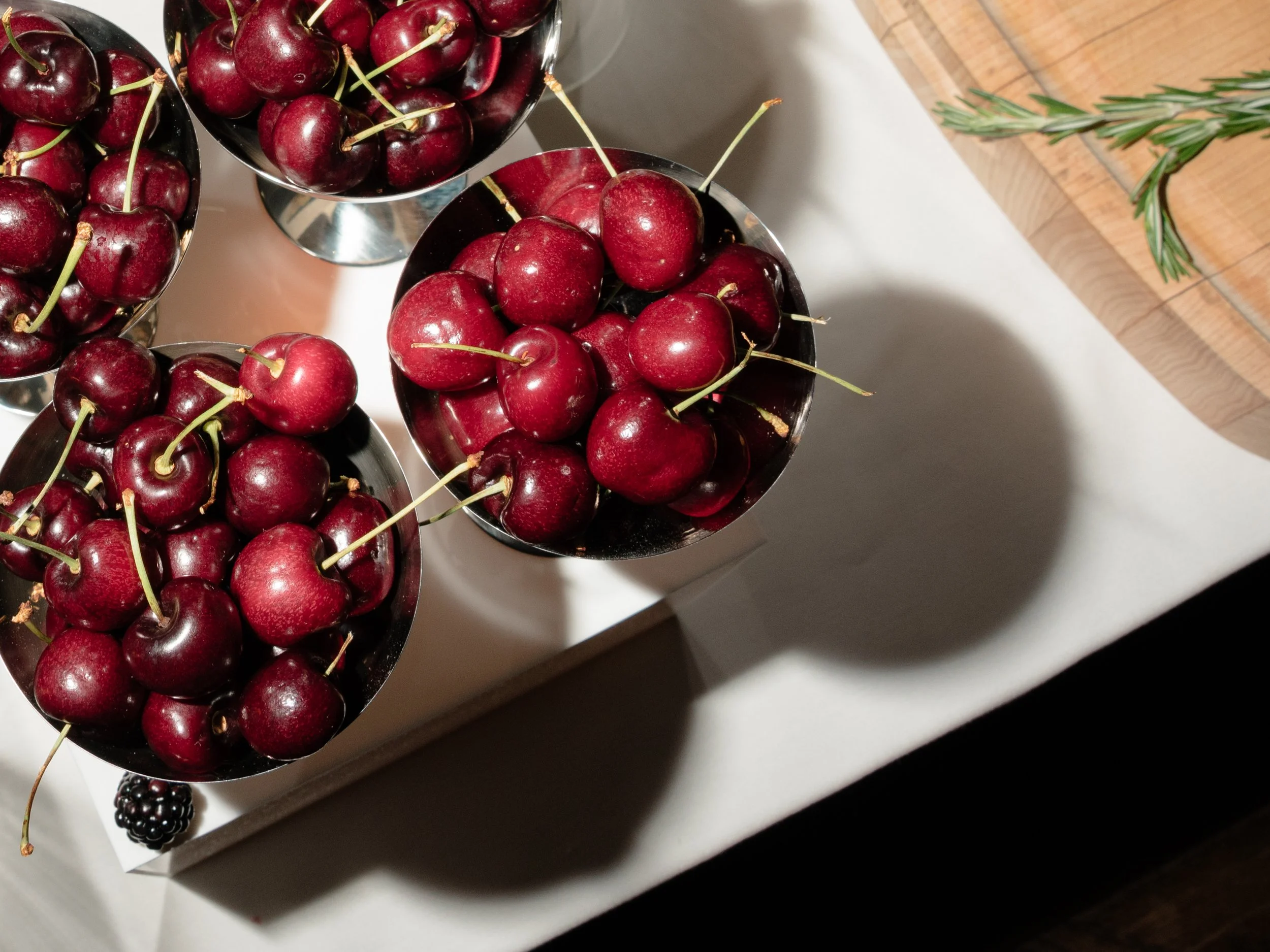 Bright red cherries arranged as part of the colorful summer rehearsal dinner food display.