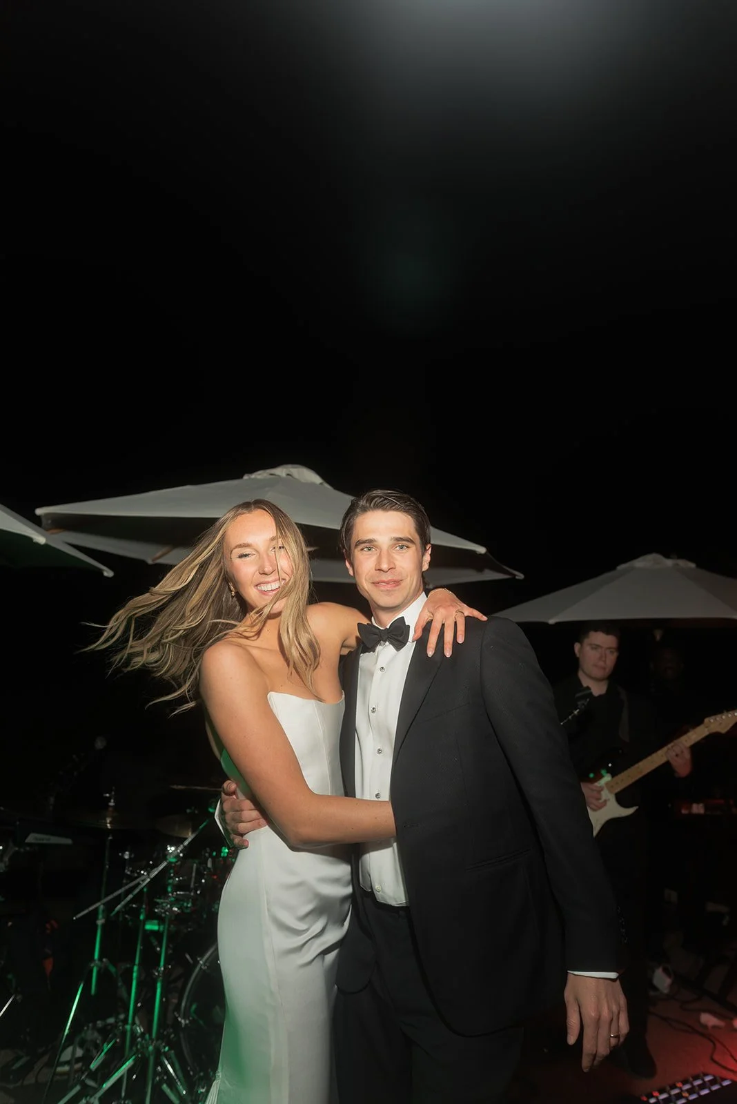 Bride dancing with groom on stage during the nighttime reception at Goodstone Inn.