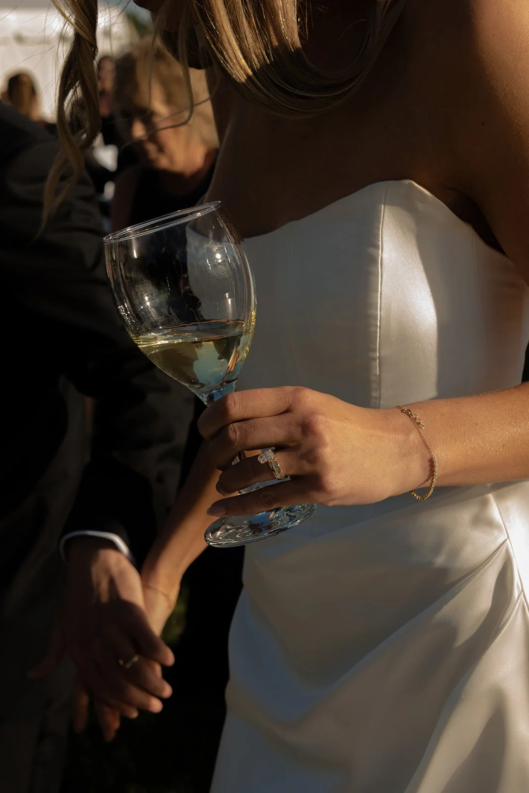 Close-up of the bride's wedding ring with a wine glass in hand during dinner at Goodstone Inn.