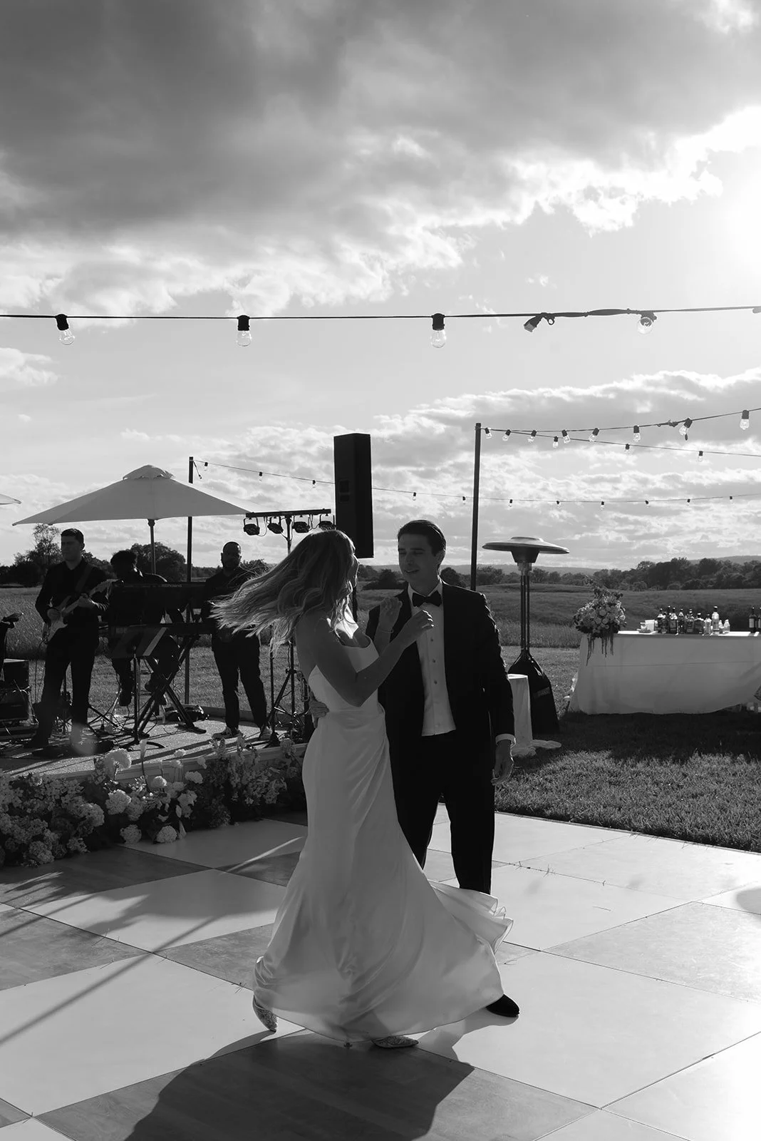 Black-and-white photograph of the bride and groom dancing outdoors during their Goodstone Inn reception.