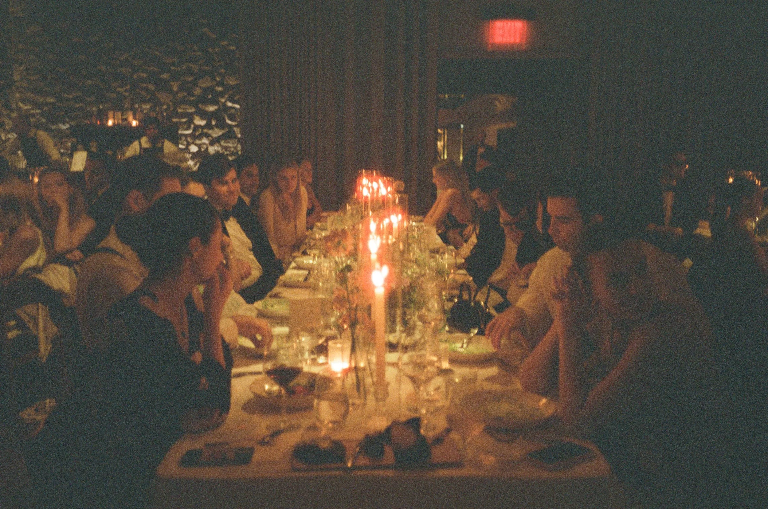 Film photograph of guests dining by candlelight during Jennie and Will’s intimate Blue Hill at Stone Barns reception.
