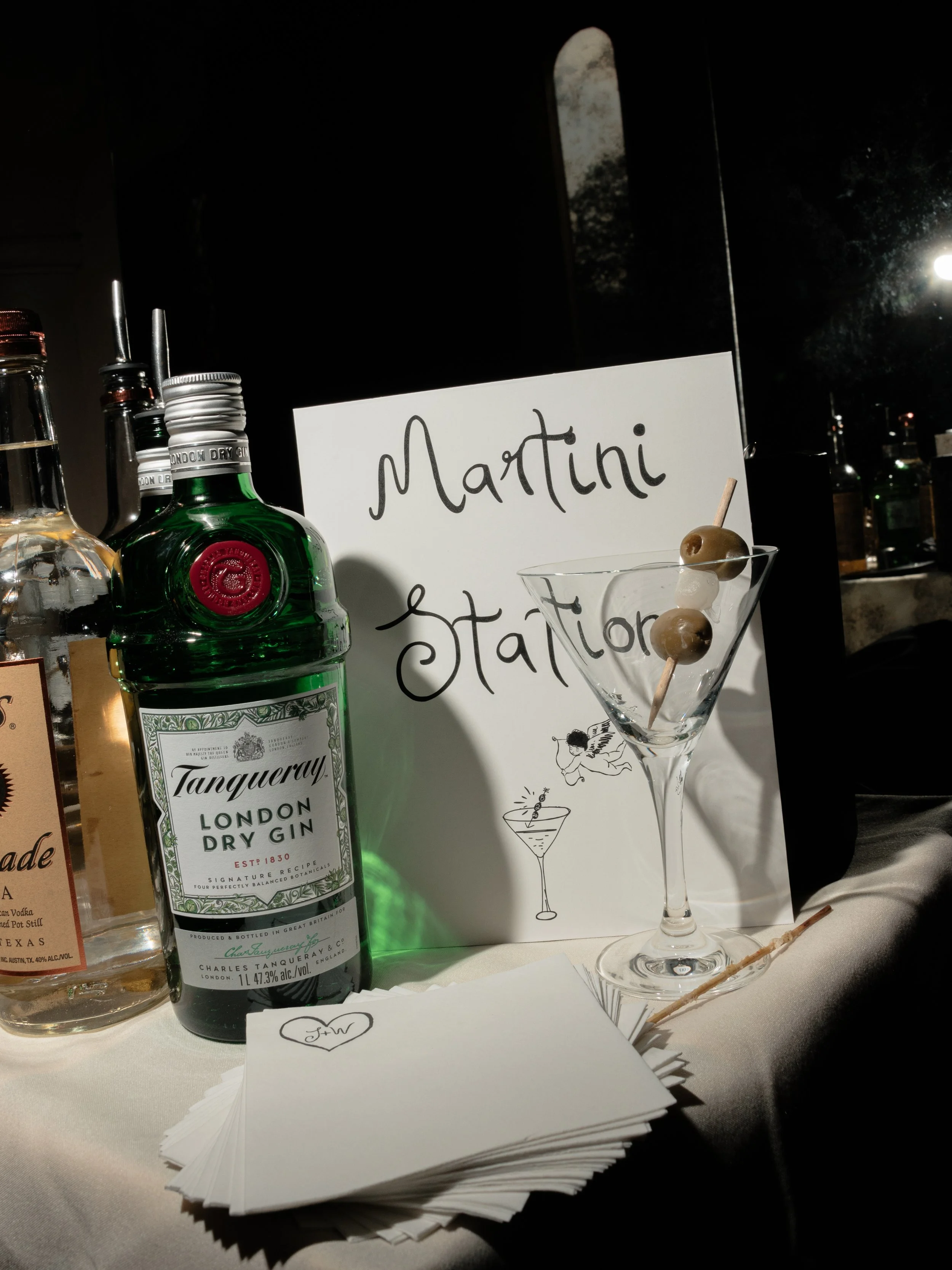  Curlicue font "Martini Station Sign" and spirits set out for Jennie and Will’s rehearsal dinner.