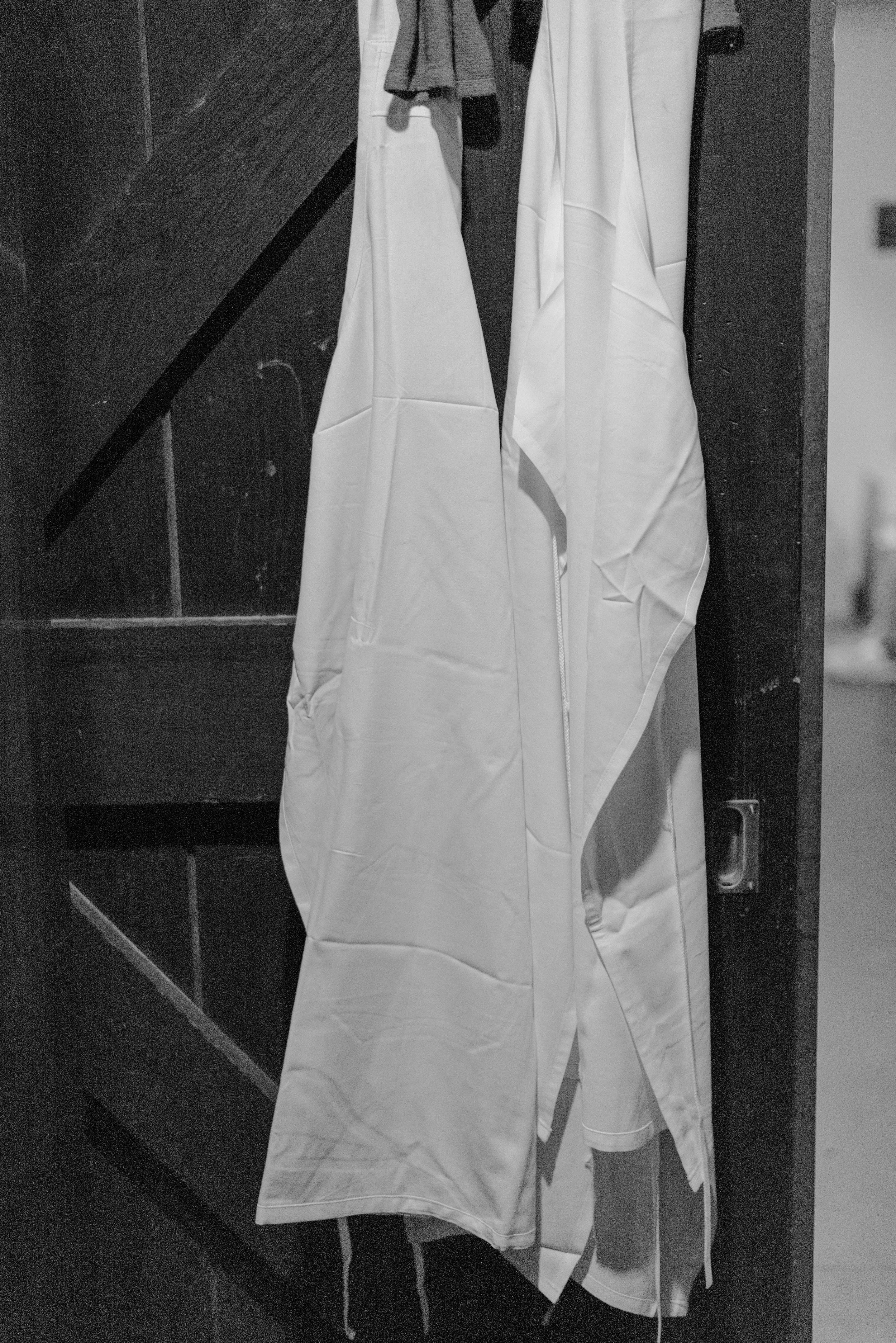Two chefs' aprons hang on the barn door outside of the kitchen at Blue Hill at Stone Barns. 