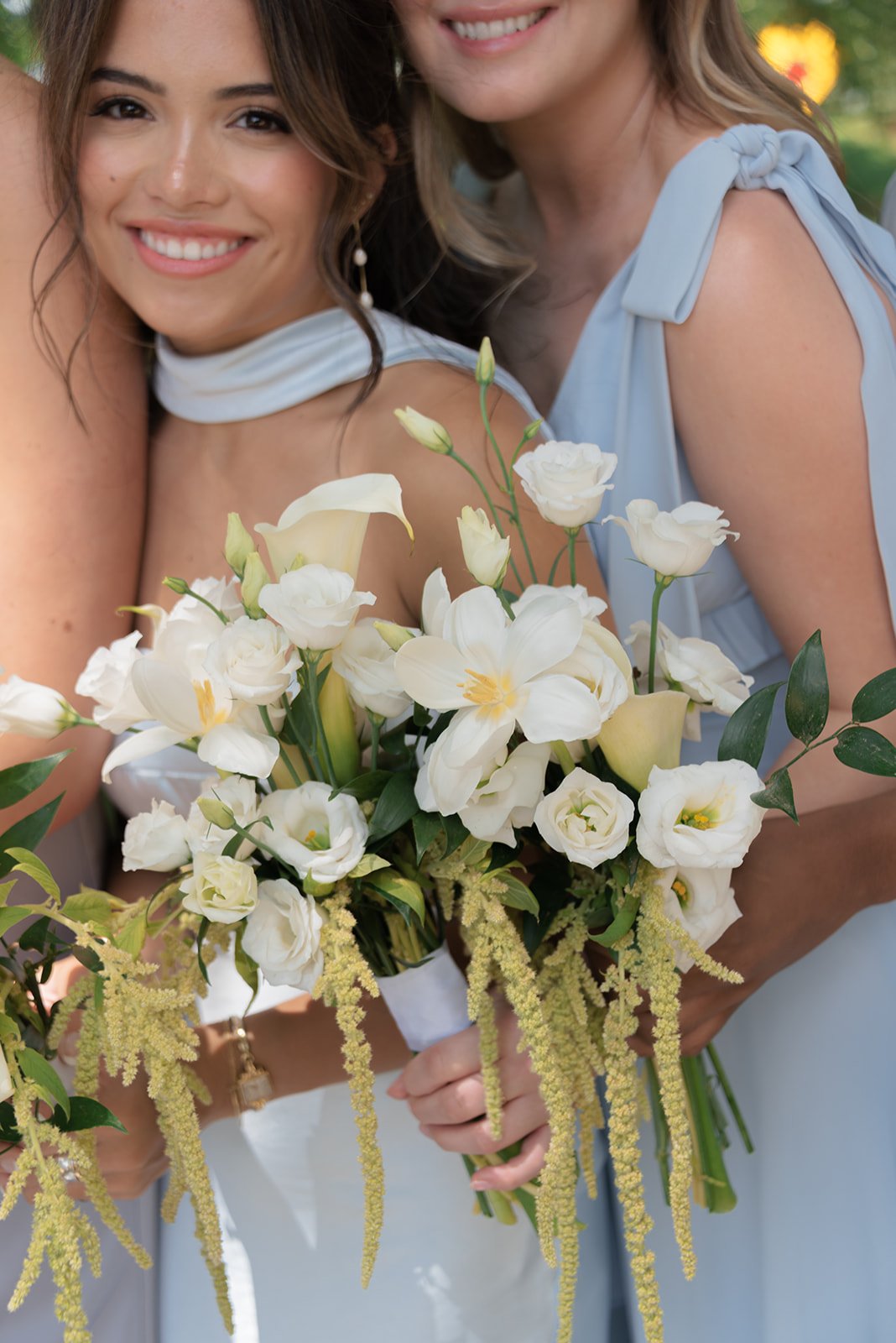 Bride and bridesmaid holding loose white wedding bouquets outdoors at Goodstone Inn in Virginia.