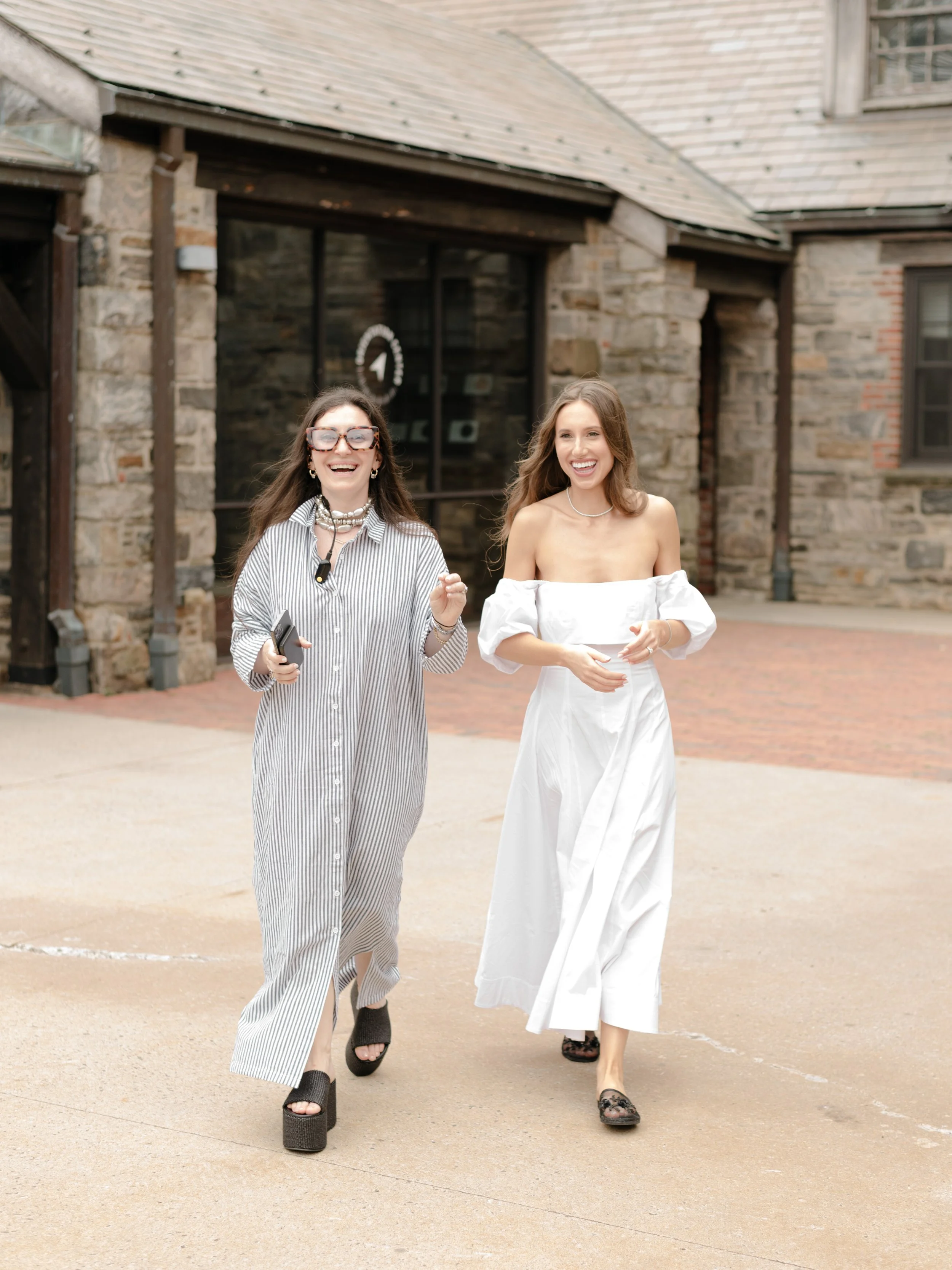 Mudari Creative wedding planner and designer Taylor walks with her bride, Jennie, across the courtyard of Blue Hill at Stone Barns before the wedding ceremony.