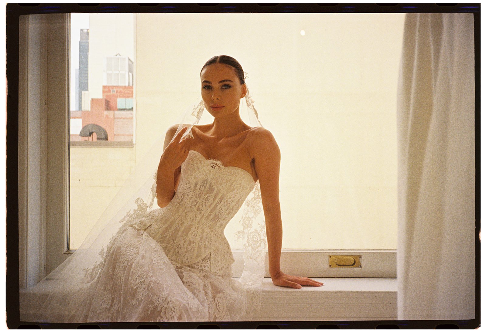 Editorial fashion portrait of a model wearing a modern wedding gown, photographed in a minimalist interior with natural light for Milla Nova Bridal during New York Bridal Fashion Week.