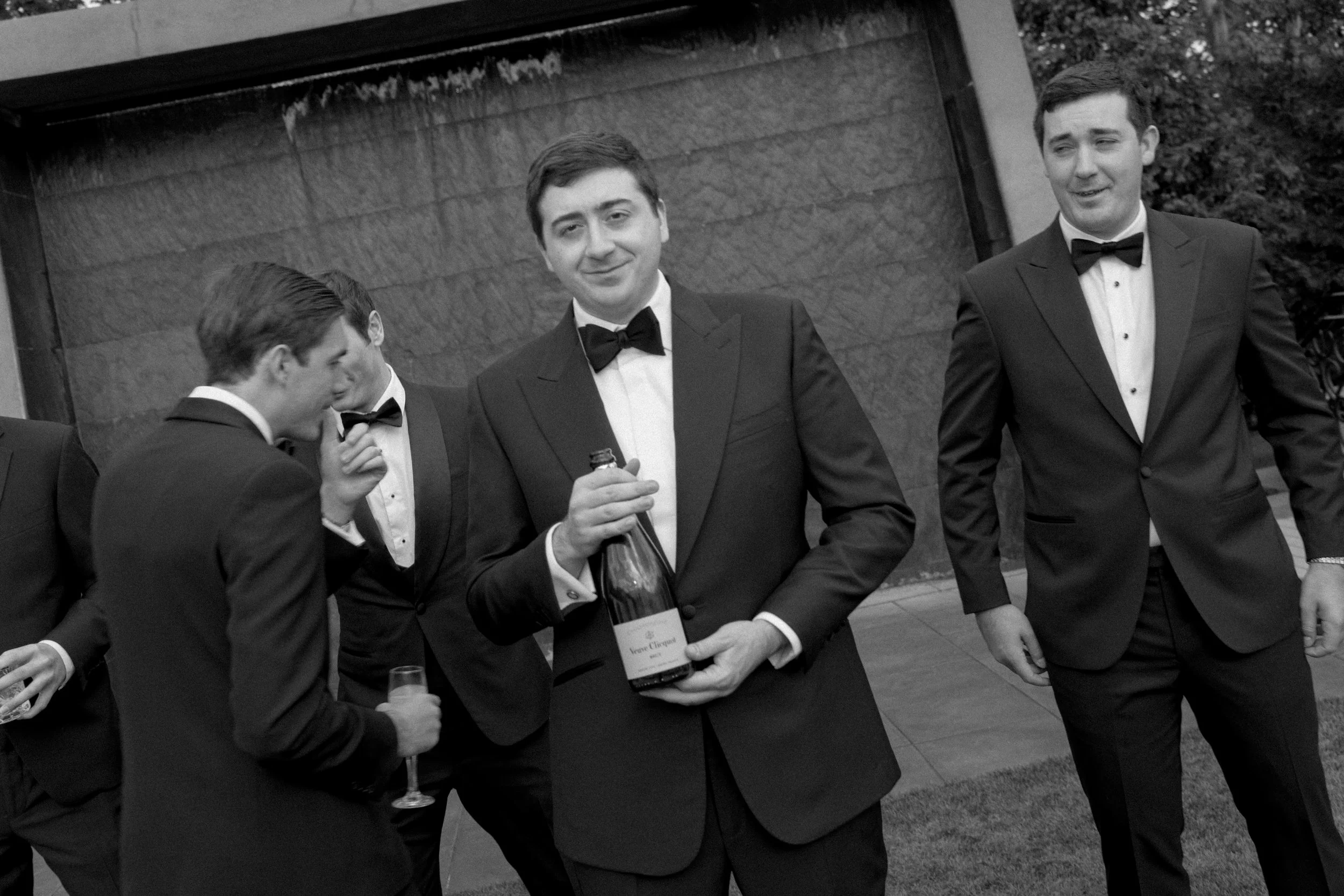 A groom sharing a candid moment with his groomsmen before the wedding ceremony.