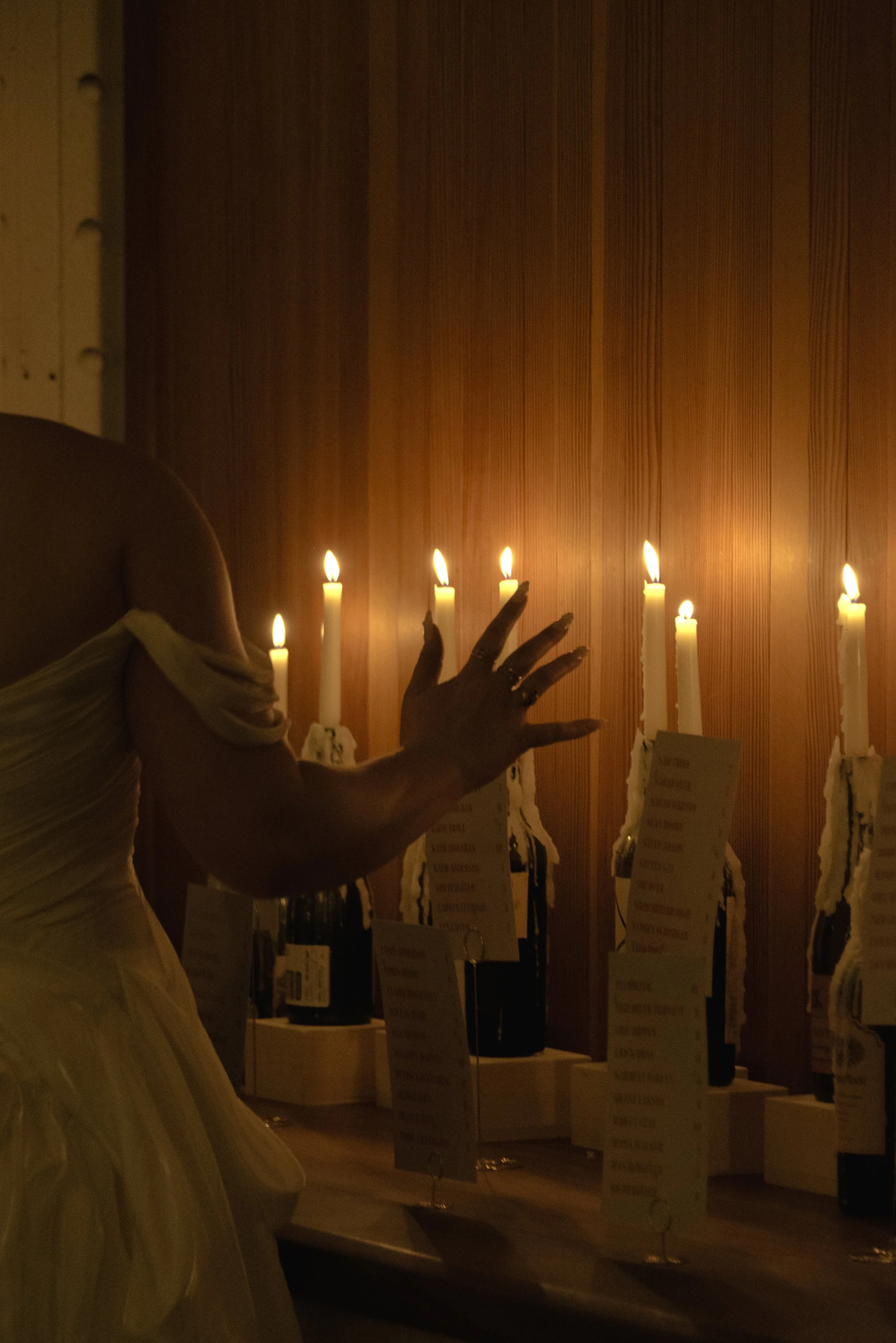 Atmospheric photograph of candlelit wedding reception tables with handwritten place settings and warm evening details at Rule of Thirds Brooklyn in Brooklyn, New York City. 