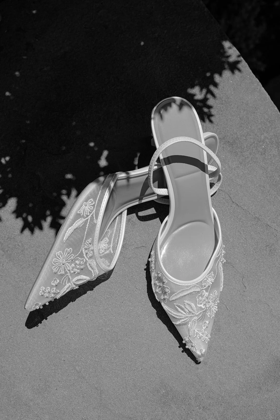 Bridal shoes photographed in black and white beside the bride’s wedding gown at Goodstone Inn.