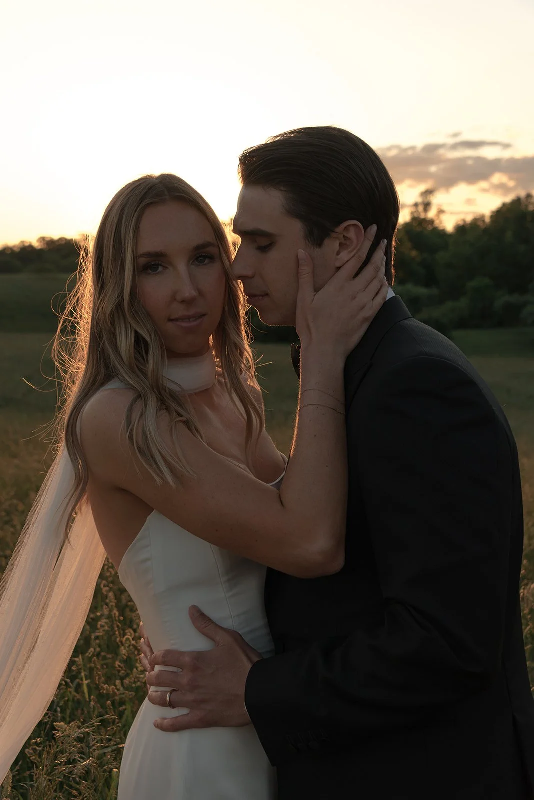 Black-and-white close portrait of the bride and groom holding each other during sunset portraits at Goodstone Inn.