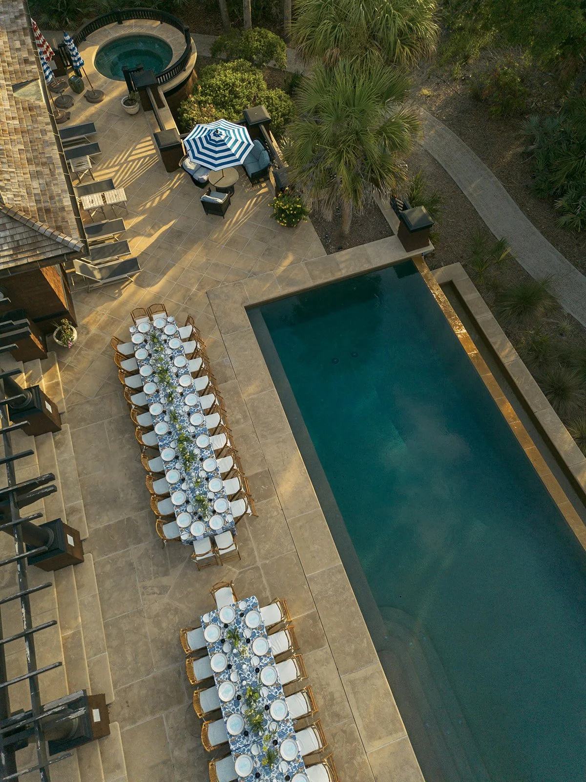 Aerial photograph of a poolside event space with outdoor dining arrangements at a private home on Kiawah Island, South Carolina, showcasing destination hospitality, architecture, and experience design.