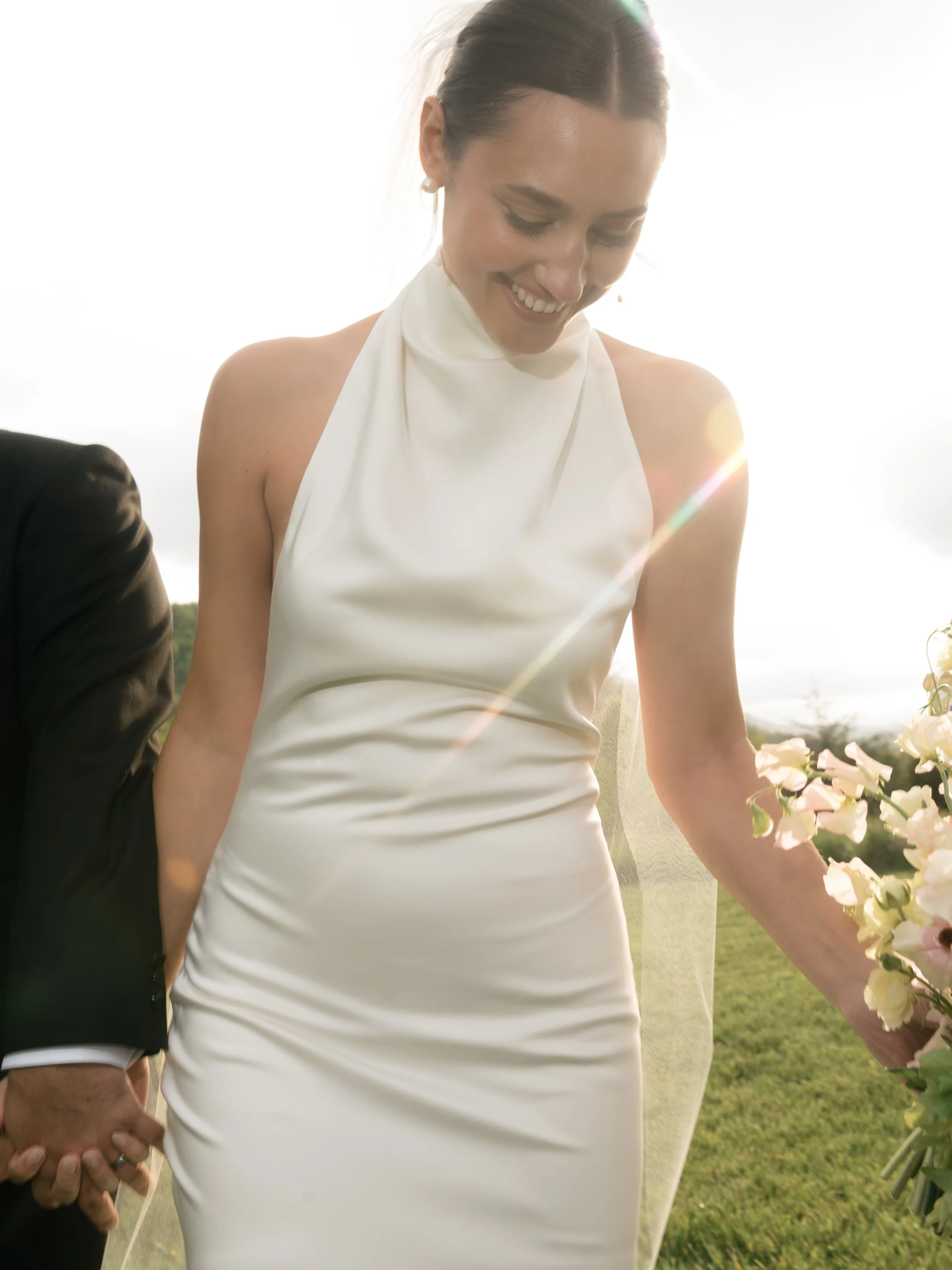 Editorial outdoor bridal portrait of a bride wearing a minimalist white wedding dress, photographed in natural sunlight at Big Spring Farm in Lexington, Virginia.