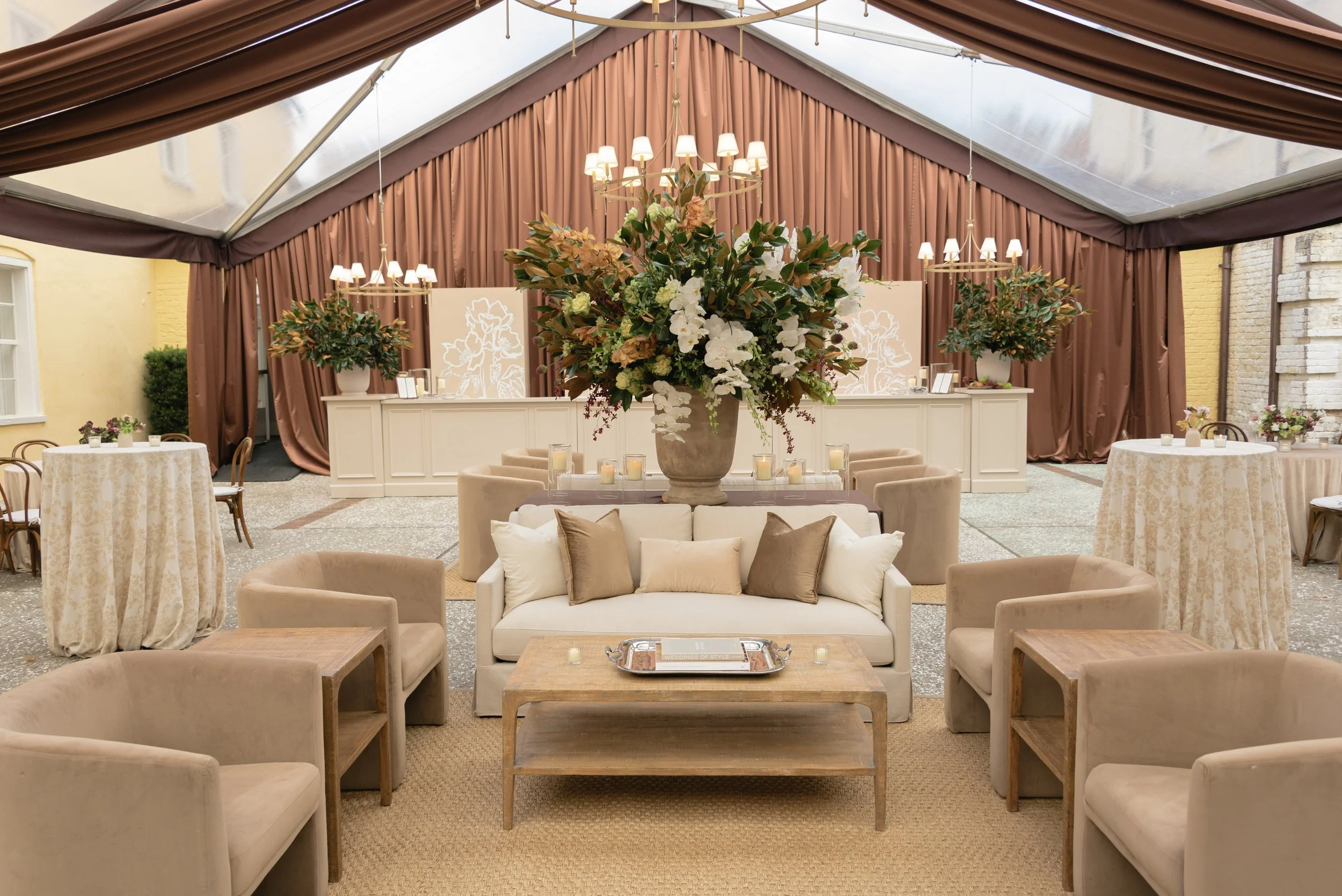 Elegant wedding reception lounge with layered seating, floral installation, and architectural details at the William Aiken House, showcasing intentional event design and hospitality.