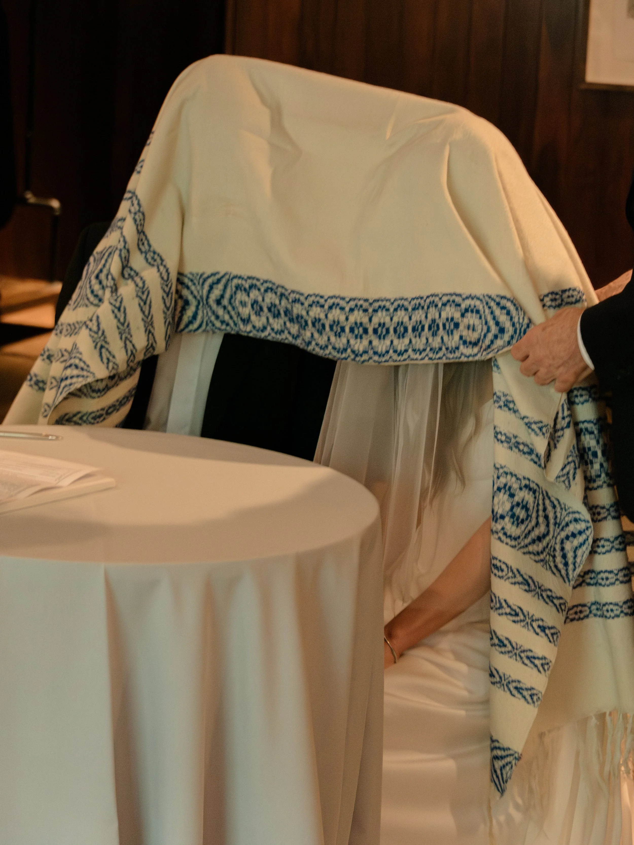 The tallit is draped over the bride and groom during the Ketubah ceremony.