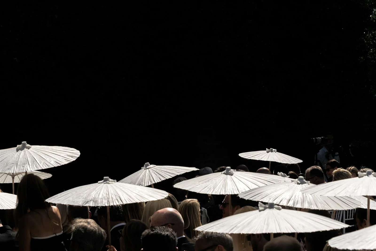 Guests gathered beneath white umbrellas during an outdoor wedding celebration at Goodstone Inn in Middleburg, Virginia, creating a graphic editorial composition of light, texture, and atmosphere.