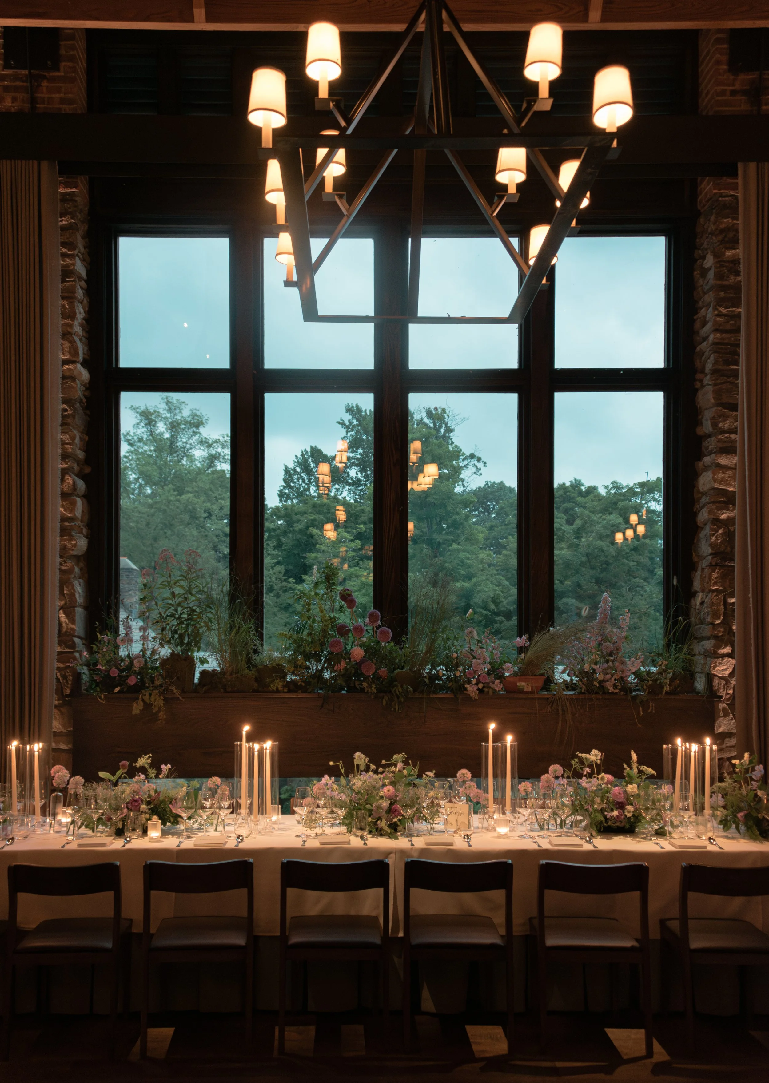 Long reception table framed by the large windows and Hudson Valley landscape at Blue Hill at Stone Barns.