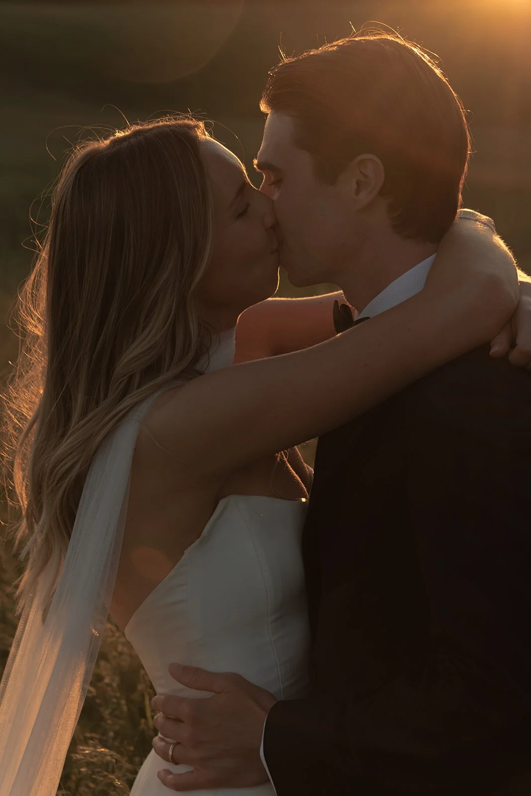 Close-up of the bride and groom kissing in warm evening light during portraits at Goodstone Inn.
