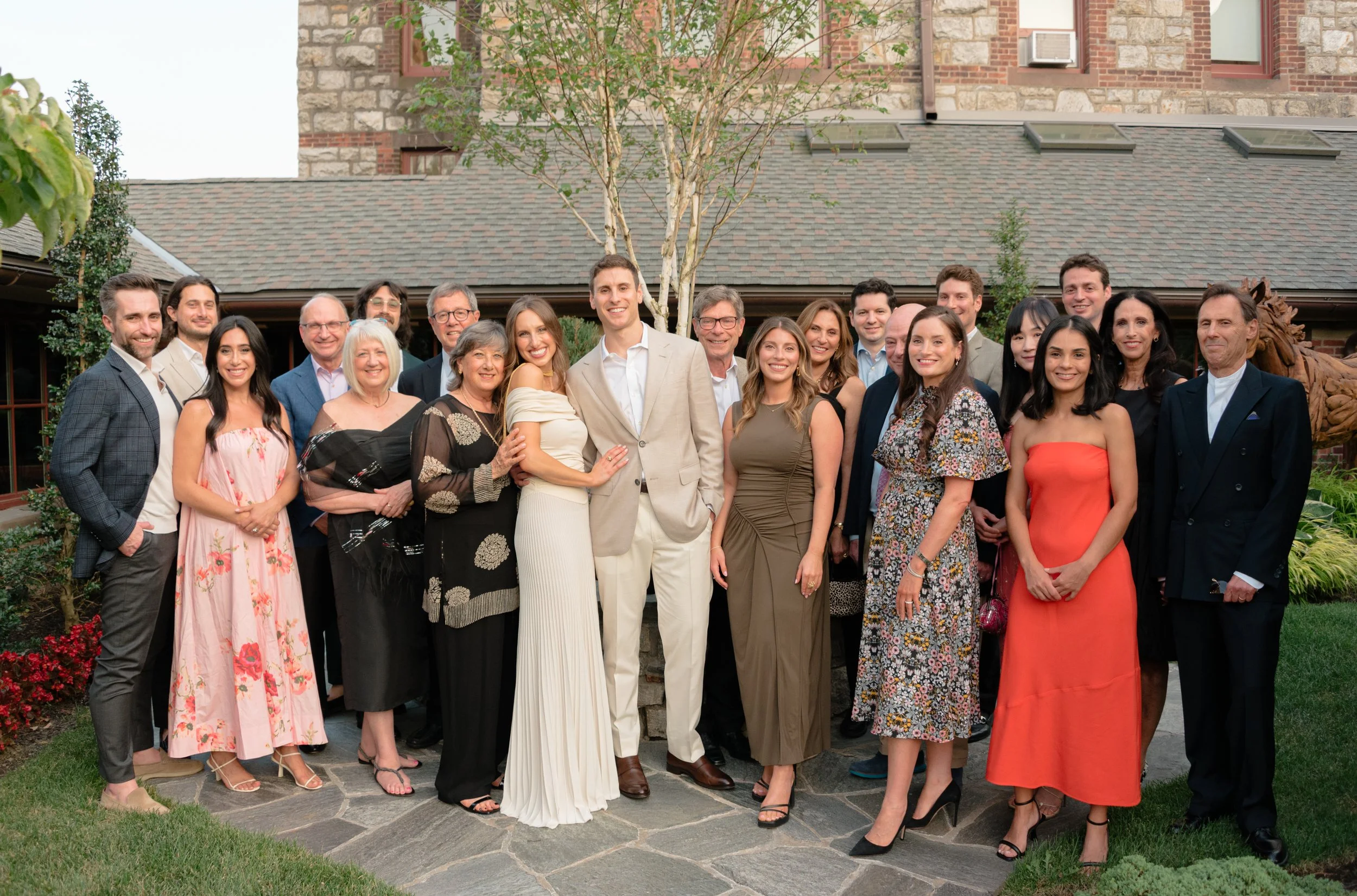 Bride and groom with their extended family gathered for a formal portrait at the rehearsal dinner.