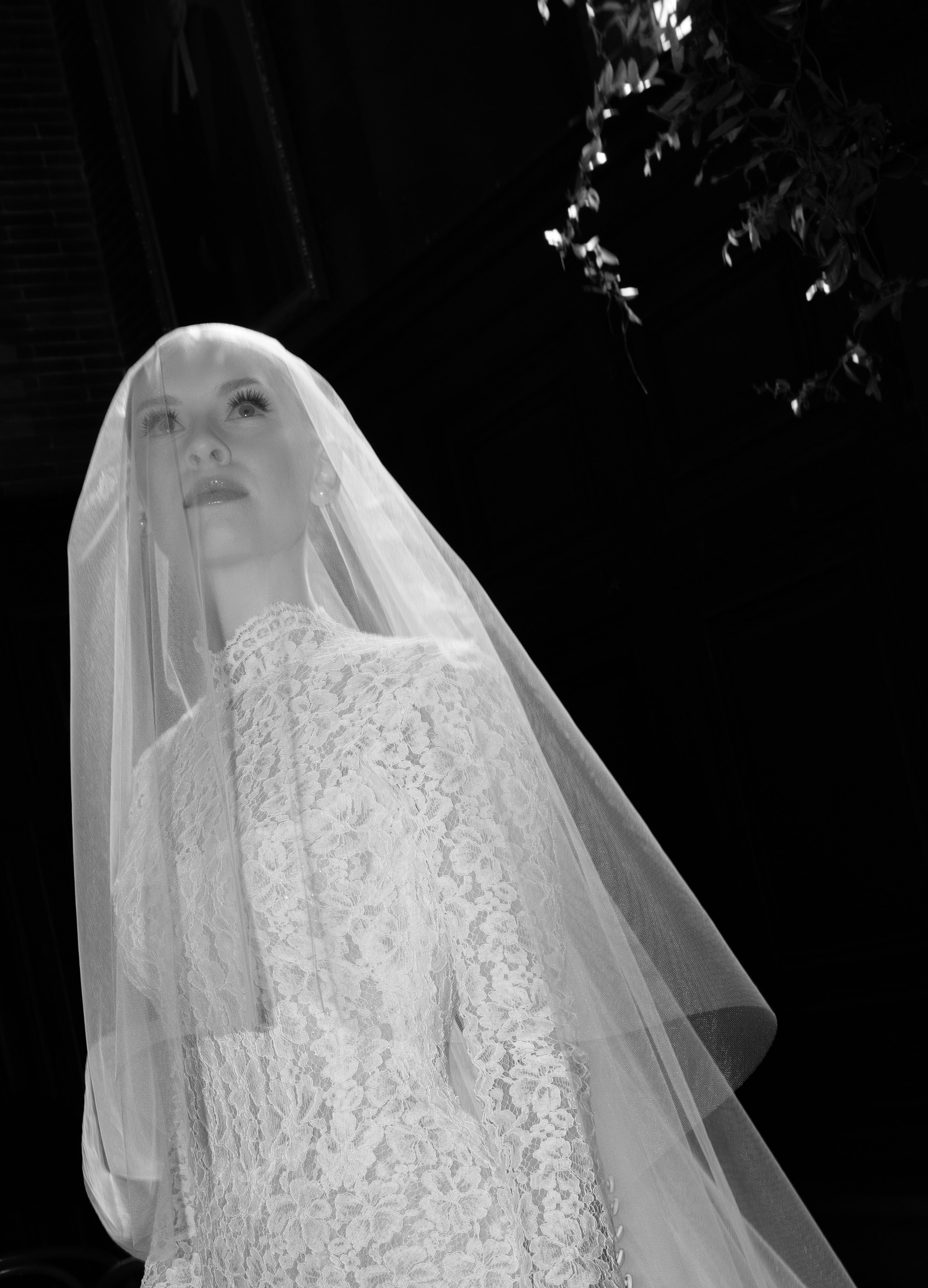 Black and white fine art wedding portrait of a veiled bride, emphasizing texture, emotion, and sculptural bridal fashion during a wedding at Chelsea Square in Manhattan, New York. 