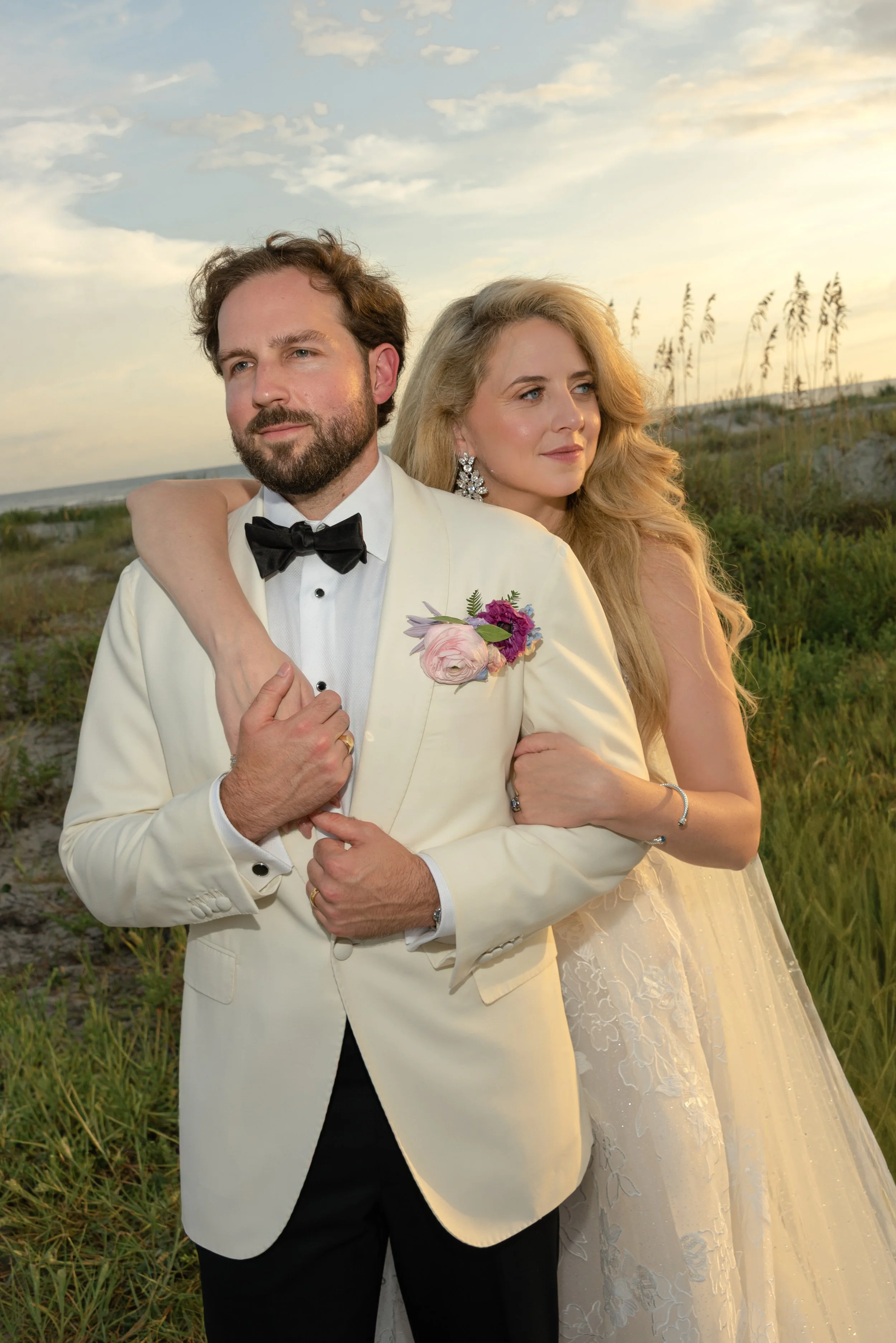 Katie embraces Trevor from behind during a golden-hour portrait overlooking the Kiawah Island coastline.