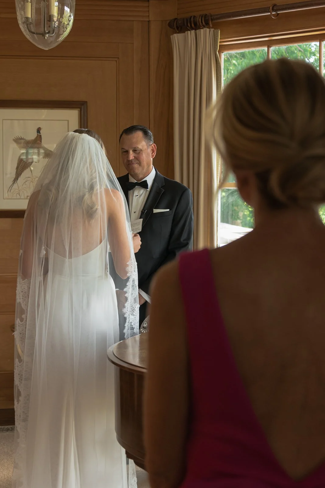 Bride's mother watches on as bride and her father share a sweet emotional moment