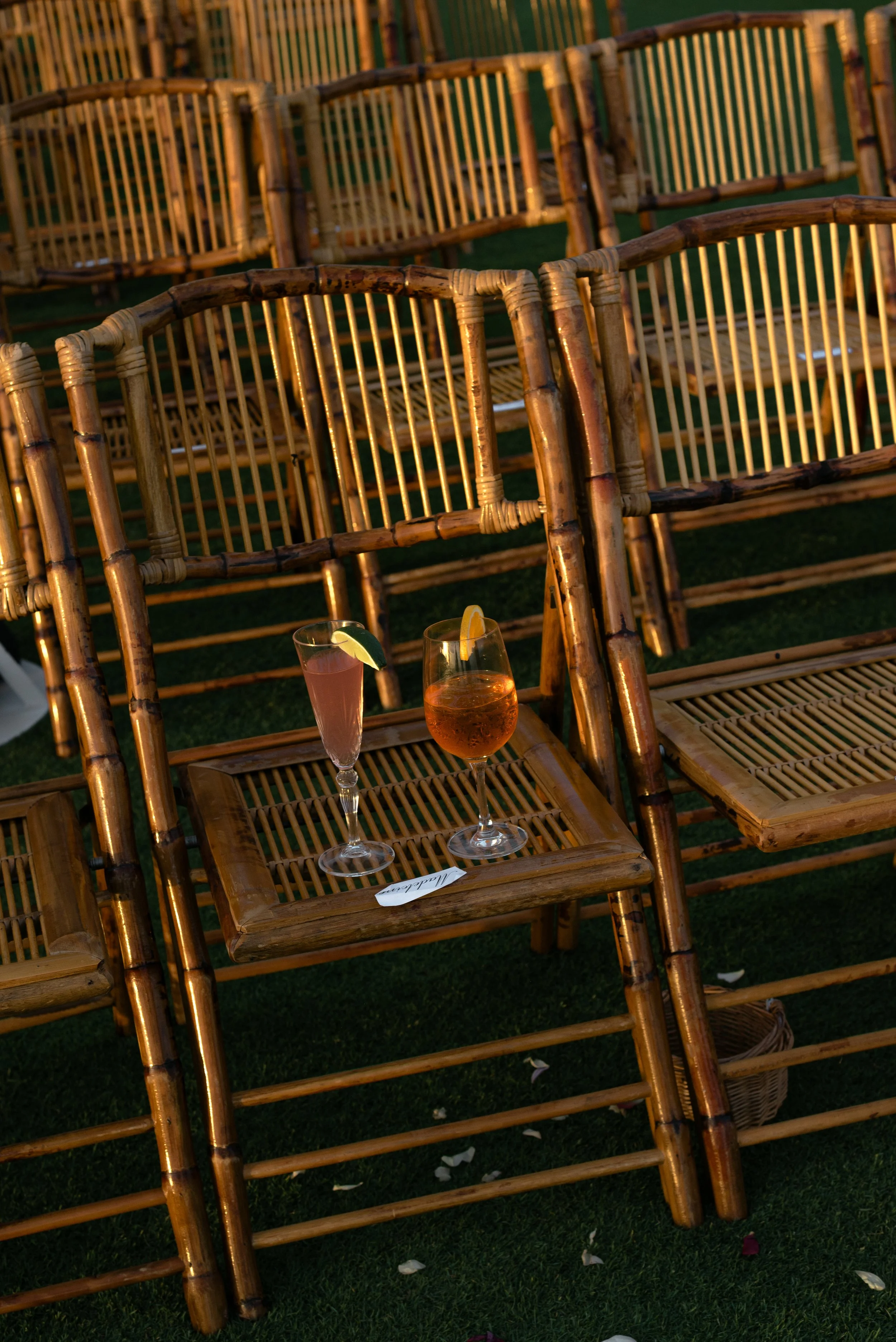 Two cocktails rest on rattan ceremony chairs after the Ocean Course wedding ceremony.
