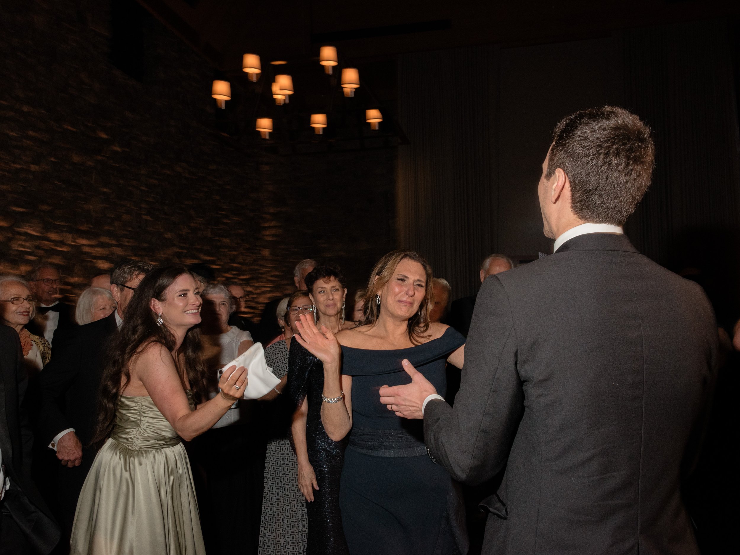 The mother of the groom becomes emotional as she has her formal dance with her son during the reception. 