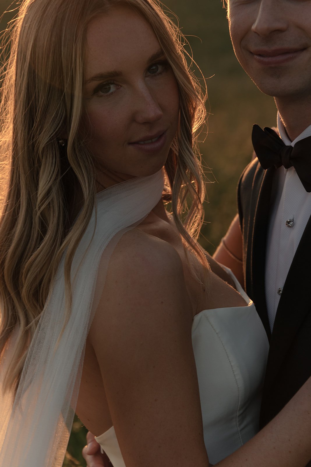 Bride smiling during a close sunset portrait in the Hayfield at Goodstone Inn.