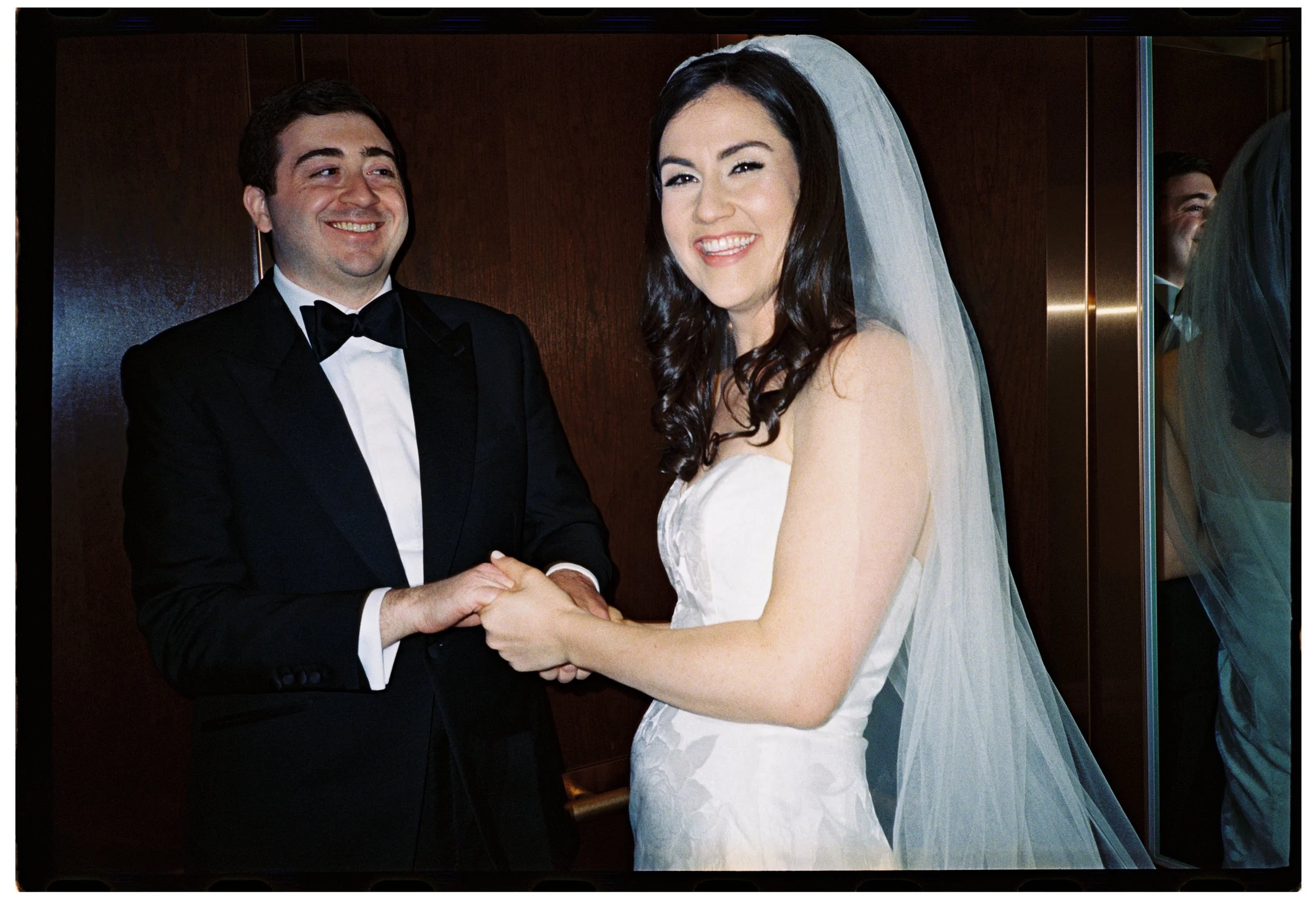 35mm film wedding portrait of a bride and groom holding hands during their celebration, captured with an intimate documentary photography style at Shadowbrook at Shrewsbury in Shrewsbury, New Jersey.