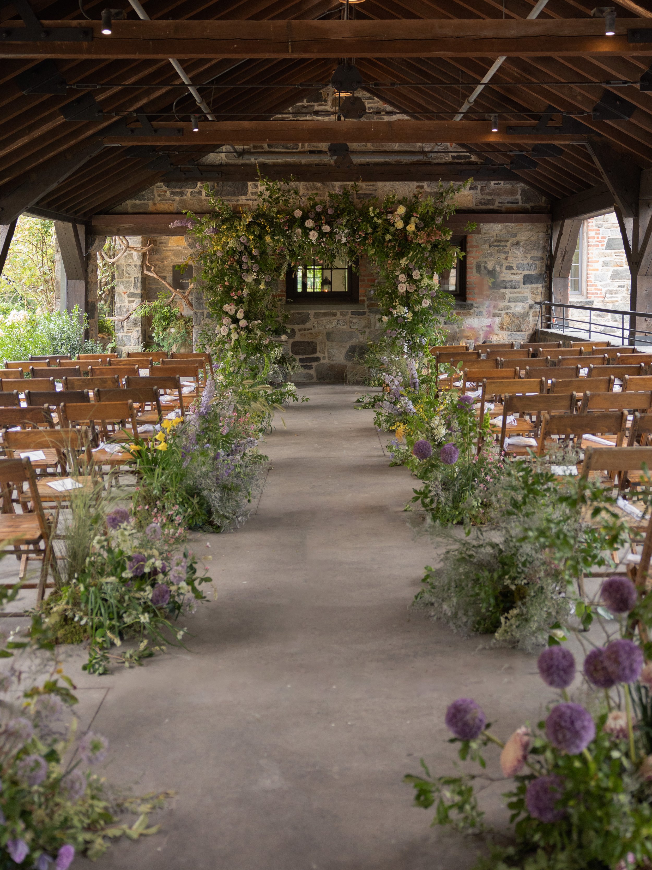 The pergola ceremony space at Blue Hill at Stone Barns designed for an elegant Hudson Valley summer wedding with florals by Wild and Birch.