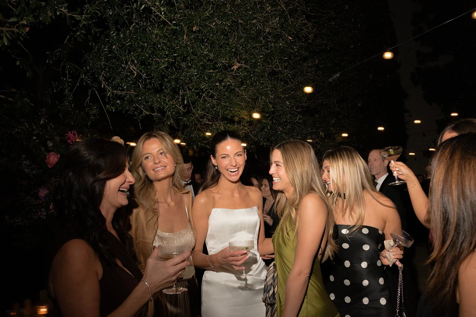 Bride laughing with friends during a wedding reception, capturing a candid moment of connection, friendship, and celebration at the Gibbes Museum in Charleston, South Carolina.