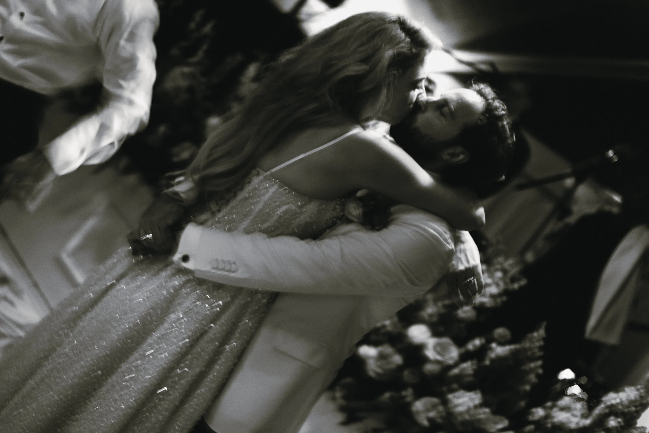 Black-and-white photograph of Katie embracing Trevor on the dance floor during their Ocean Course reception.