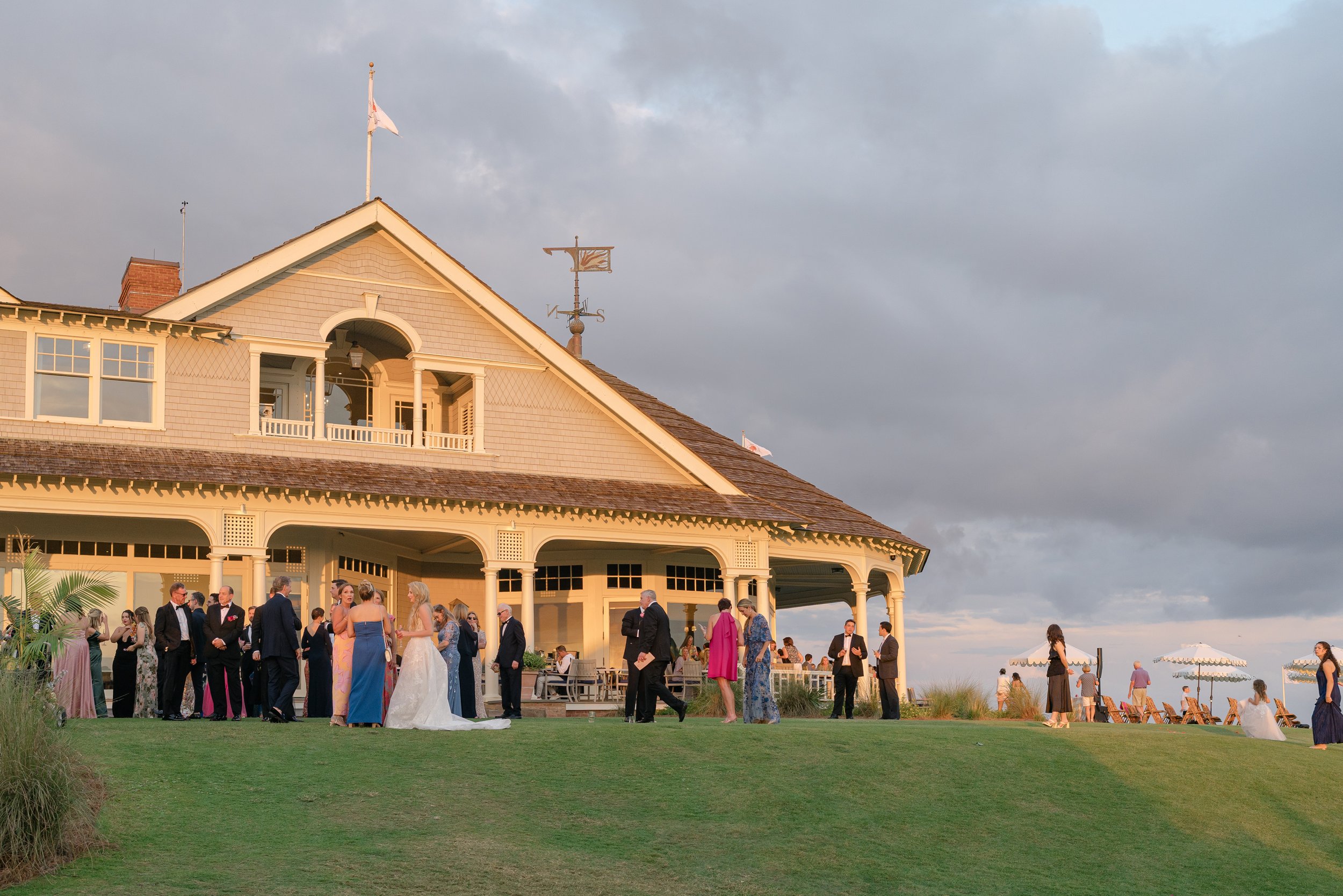 Guests gather outside Turtle Point Clubhouse during cocktail hour following Katie and Trevor’s Ocean Course wedding ceremony
