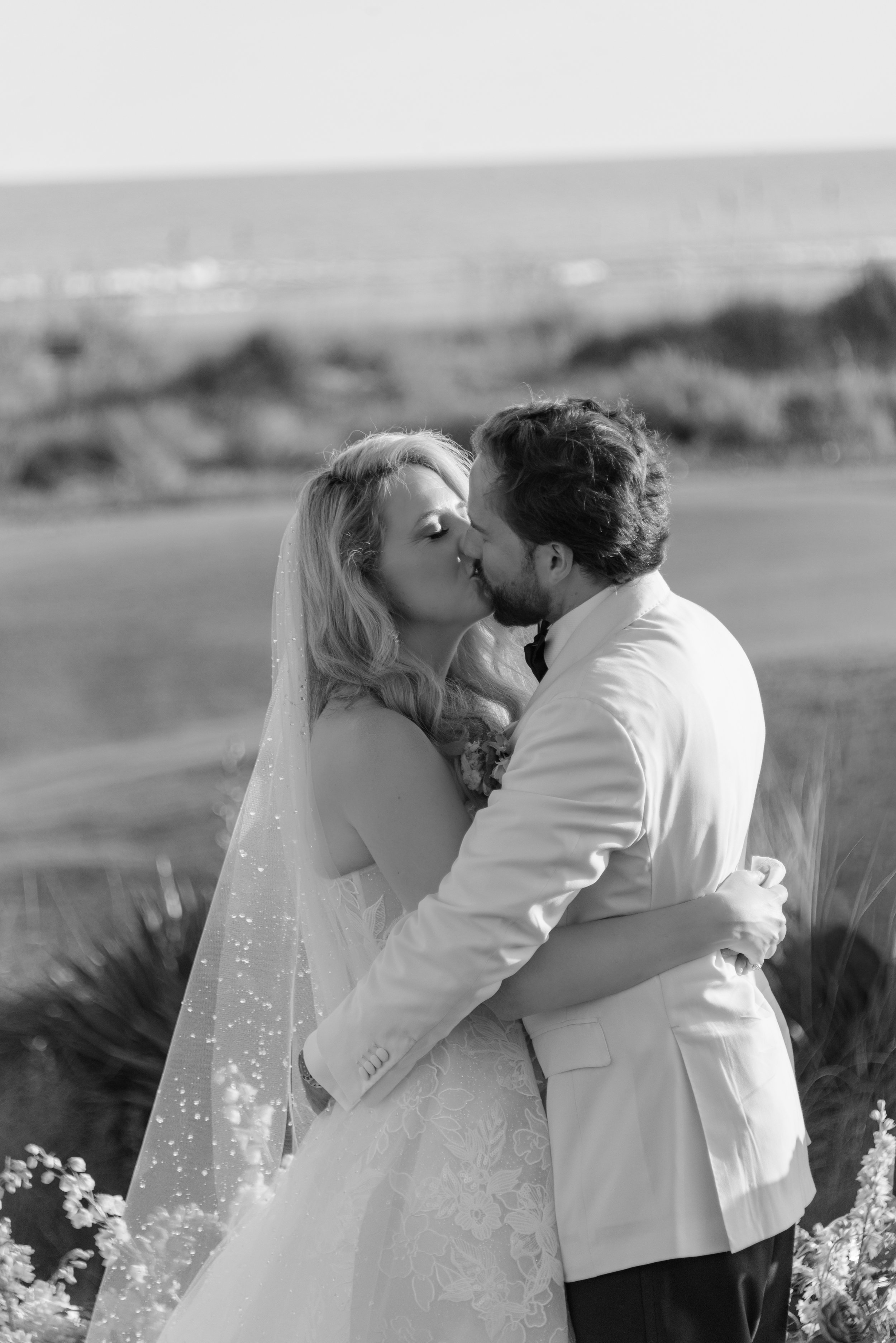 Black-and-white close-up of Katie and Trevor kissing immediately after their wedding ceremony at The Ocean Course.