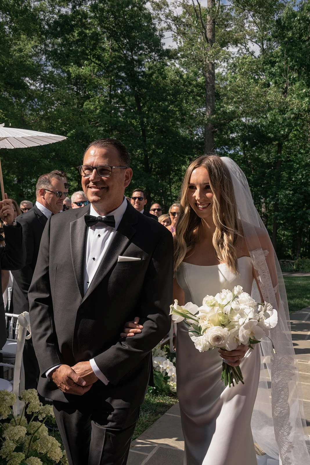 Bride and her father walk down the aisle together at the Ivy Wall at Goodstone Inn