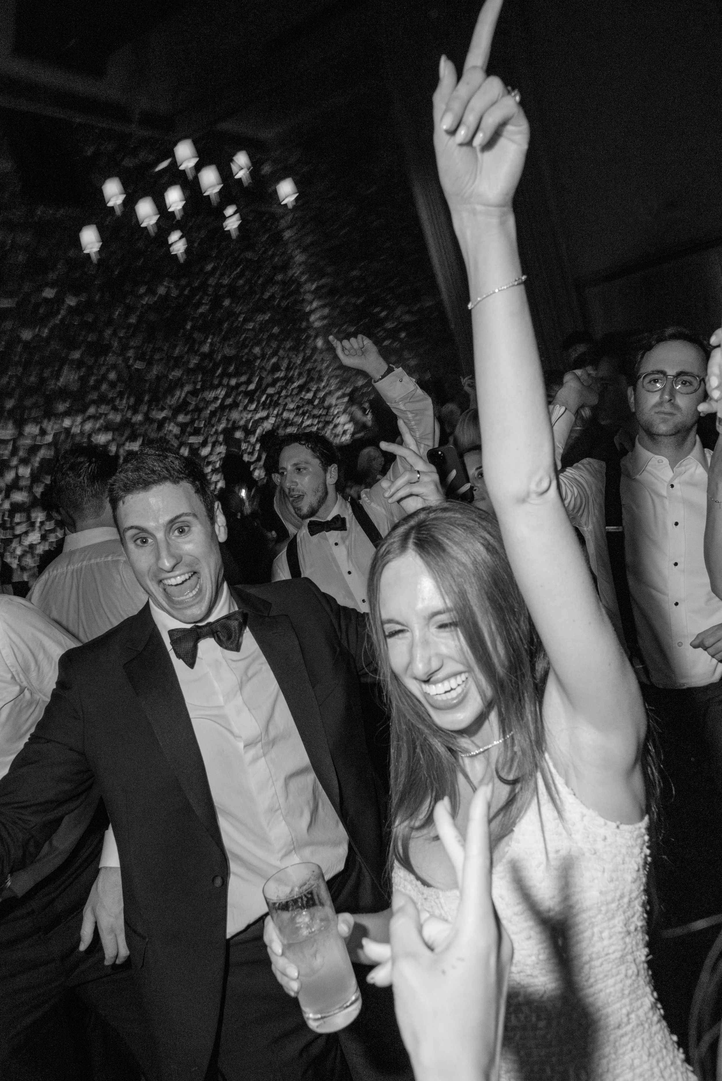 Black-and-white dance-floor candid of guests celebrating with Jennie and Will during the reception.