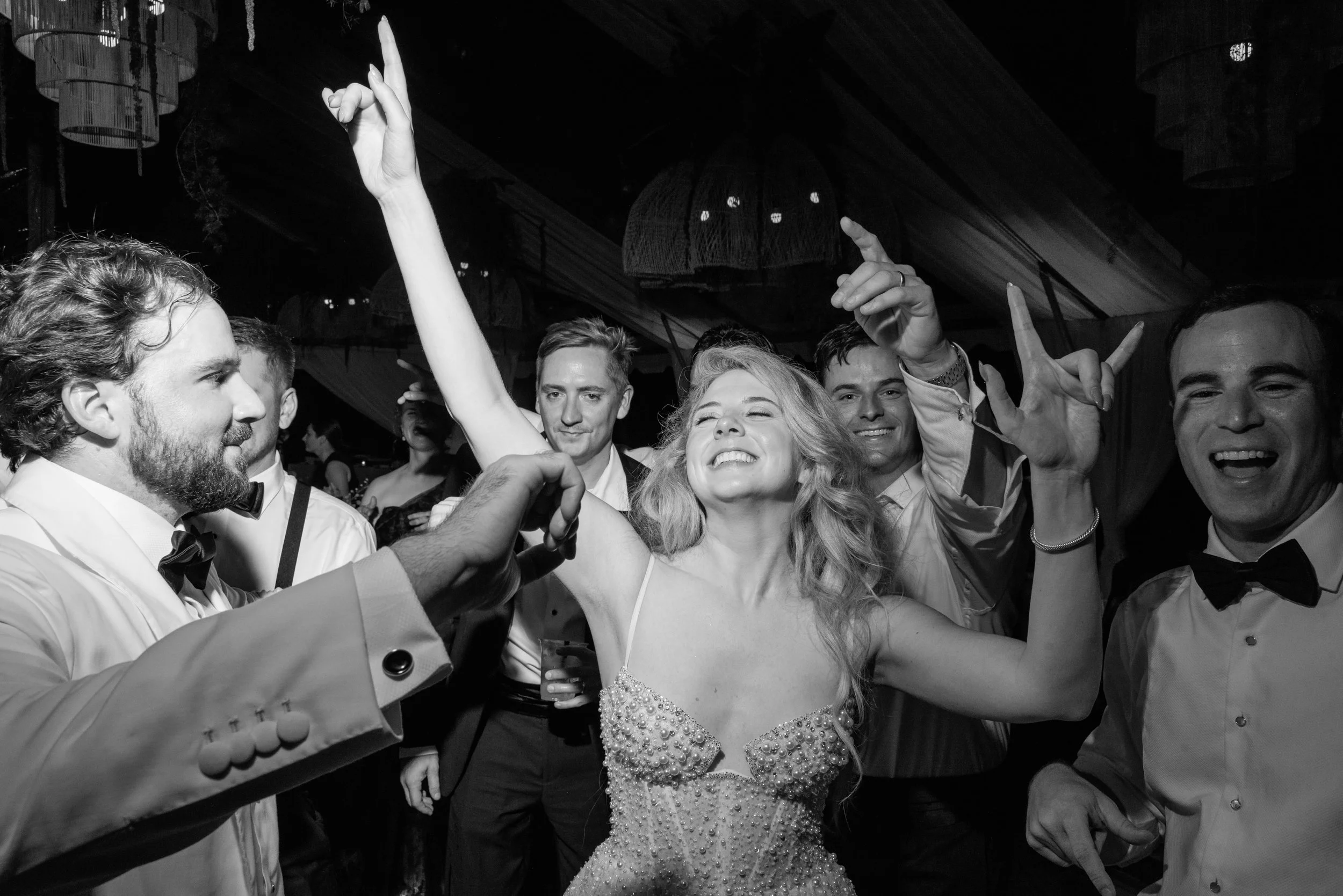 Black-and-white photograph of Katie dancing joyfully among guests during the final moments of the reception.