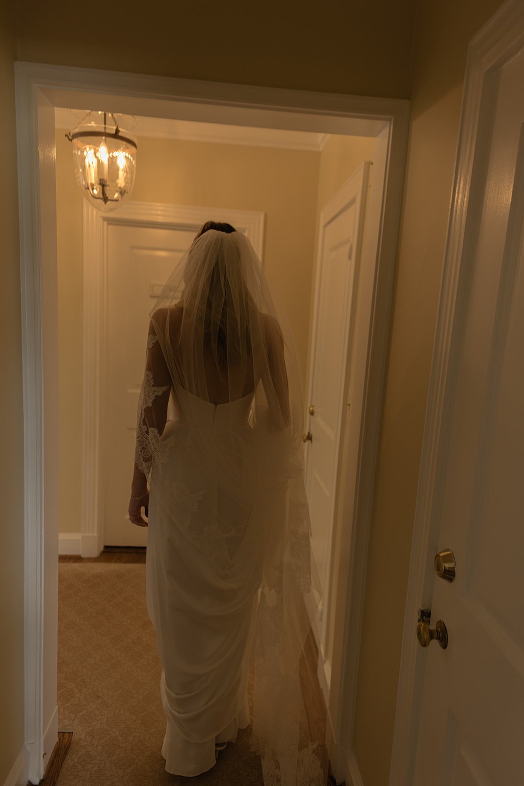 Bride moves through a softly lit room at the Manor House at Goodstone Inn.