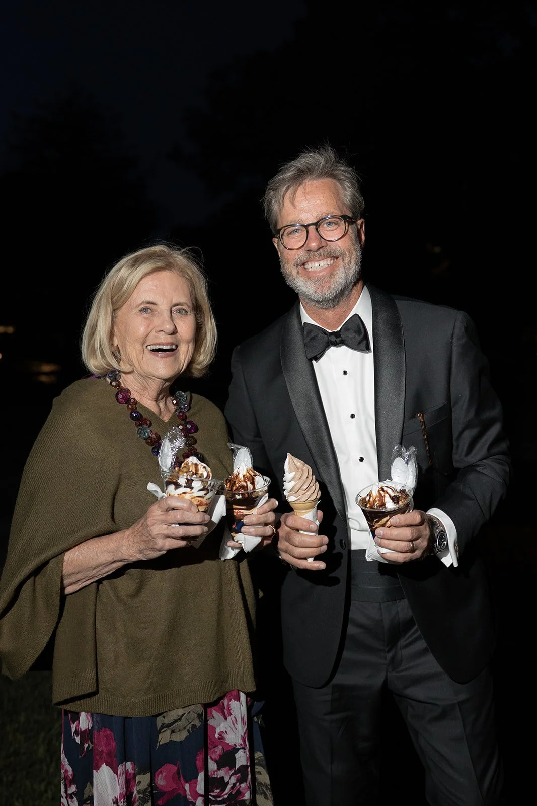 Wedding guests holding ice cream cones from Mr. Softee DMV and smiling during the evening reception at Goodstone Inn.