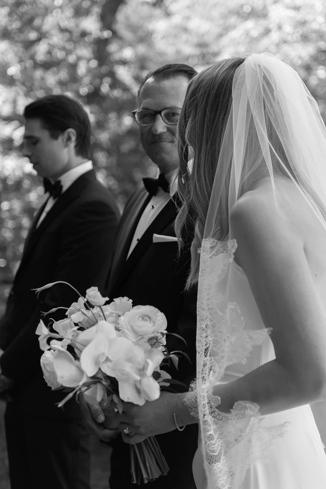 Black-and-white close-up of the bride holding a white bouquet during the ceremony at Goodstone Inn.