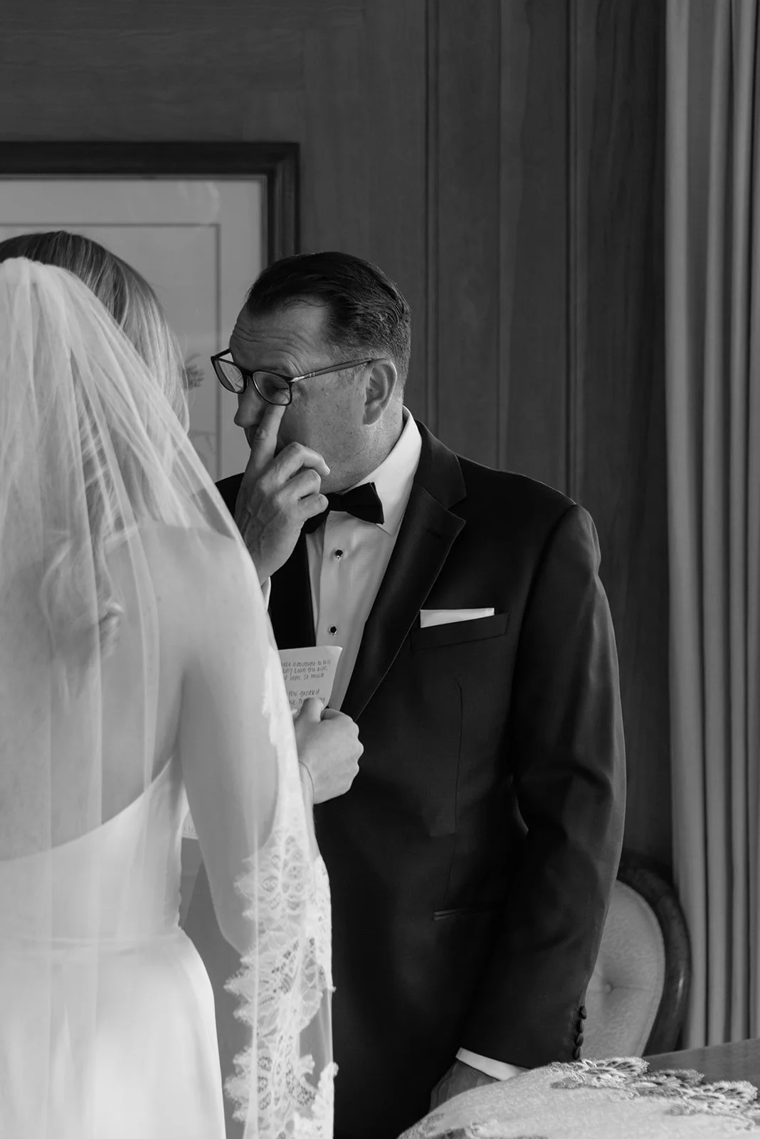 Black-and-white photograph of the bride and her father sharing an emotional first look at Goodstone Inn.