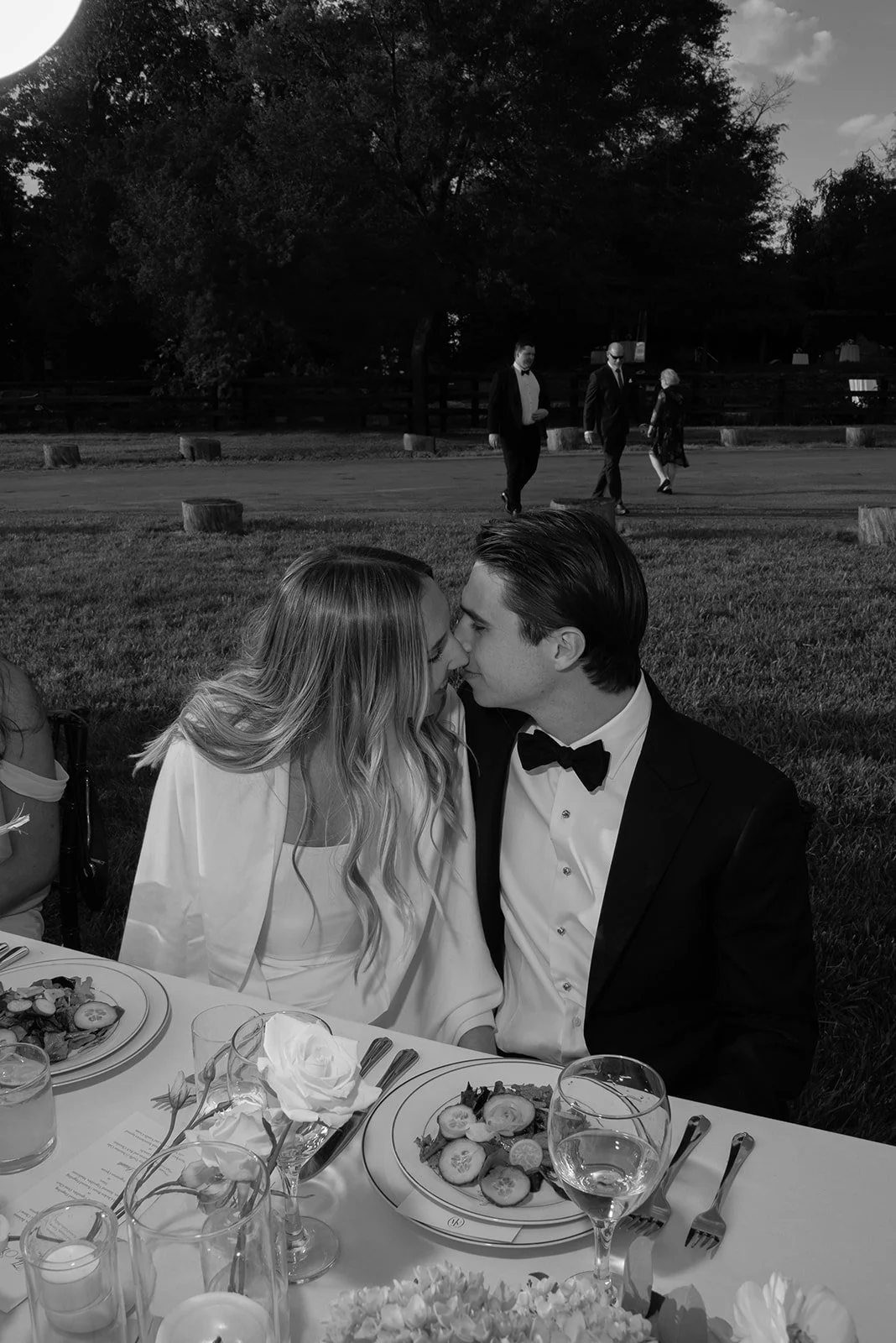 Black-and-white candid of wedding guests seated together during dinner at Goodstone Inn