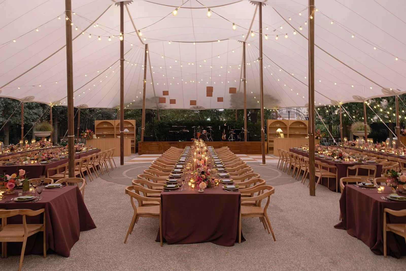 Elegant outdoor wedding reception design beneath a sailcloth tent with string lights, layered tablescapes, and intentional details at the Gibbes Museum in Charleston, SC.