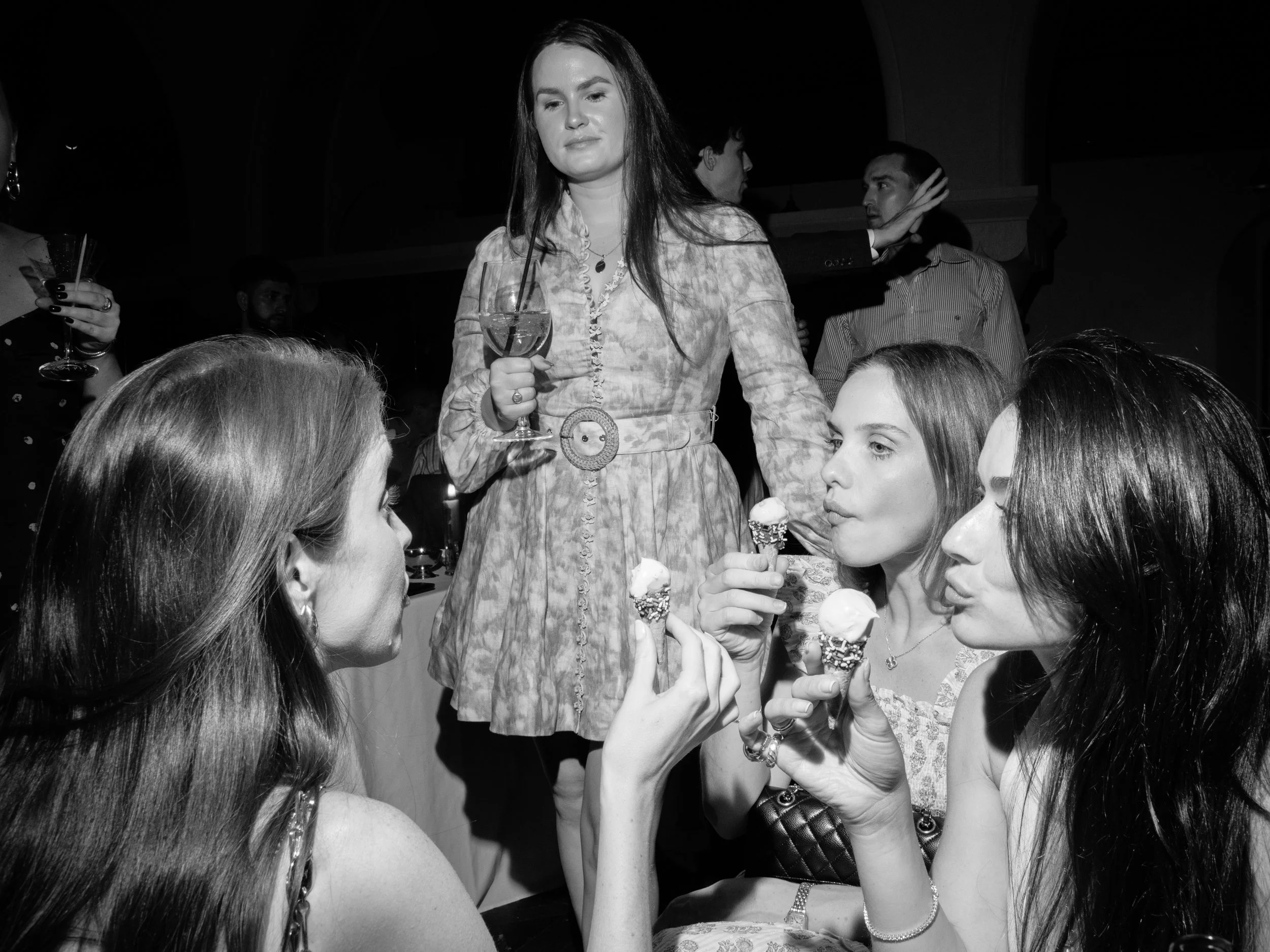 Black-and-white photograph of women enjoying the mini ice-cream cones during the rehearsal dinner at The Abbey Inn and Spa in Hudson Valley, NY. 