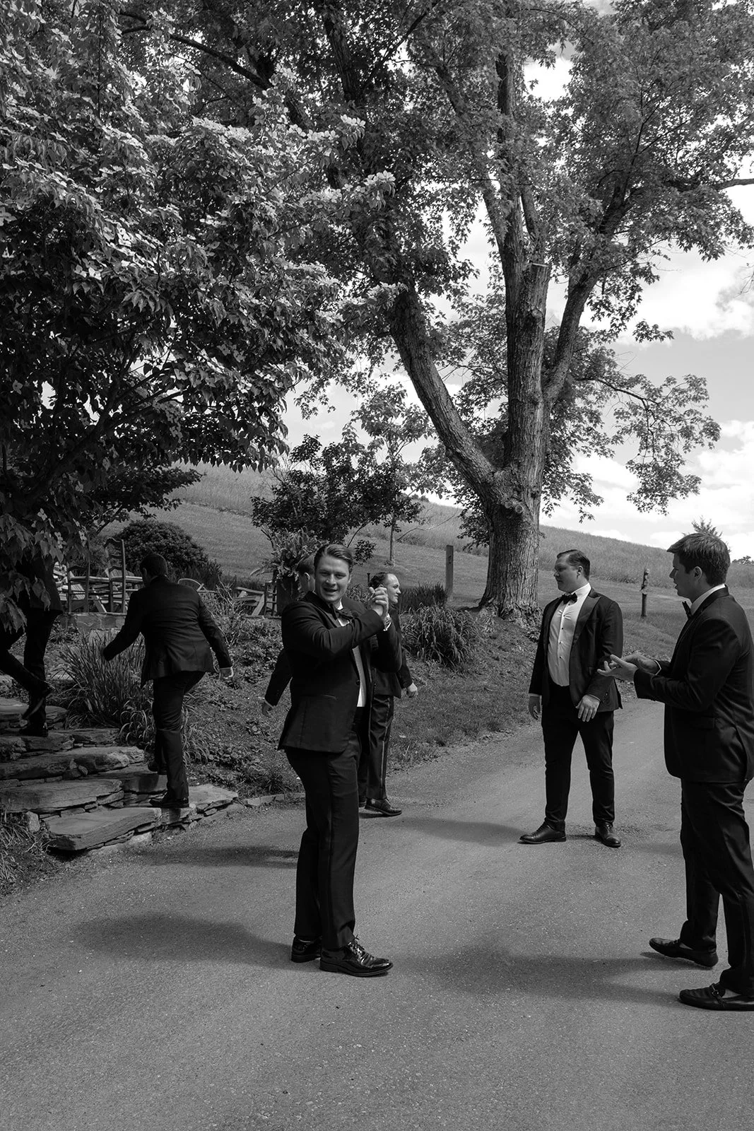 Black-and-white photograph of guests walking through the grounds at Goodstone Inn before the ceremony.