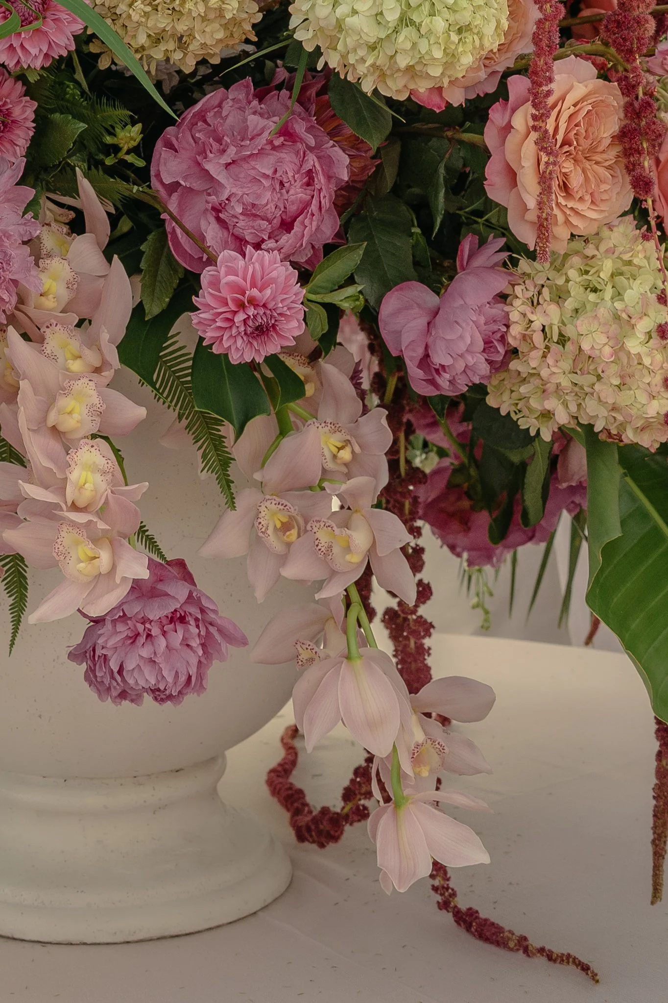 Close view of pink peonies, orchids, hydrangeas, and trailing flowers arranged by Festoon for the Ocean Course wedding ceremony.